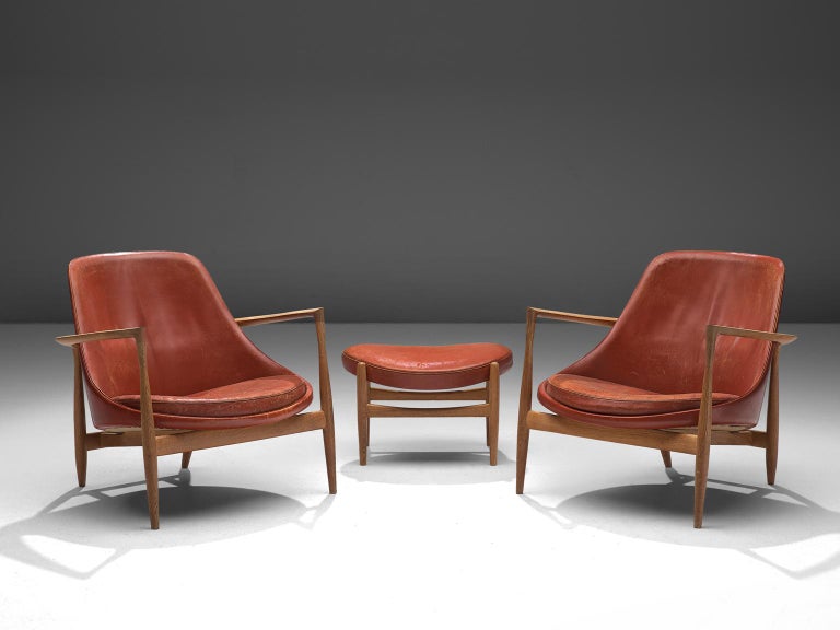 Ib Kofod-Larsen, two lounge chairs with ottoman, model U-56 'Elizabeth', oak and red leather, Denmark, 1956.

These are two of Kofod-Larsen highest-quality armchairs, with an oak frame and beautiful details in the design. The leather holds beautiful