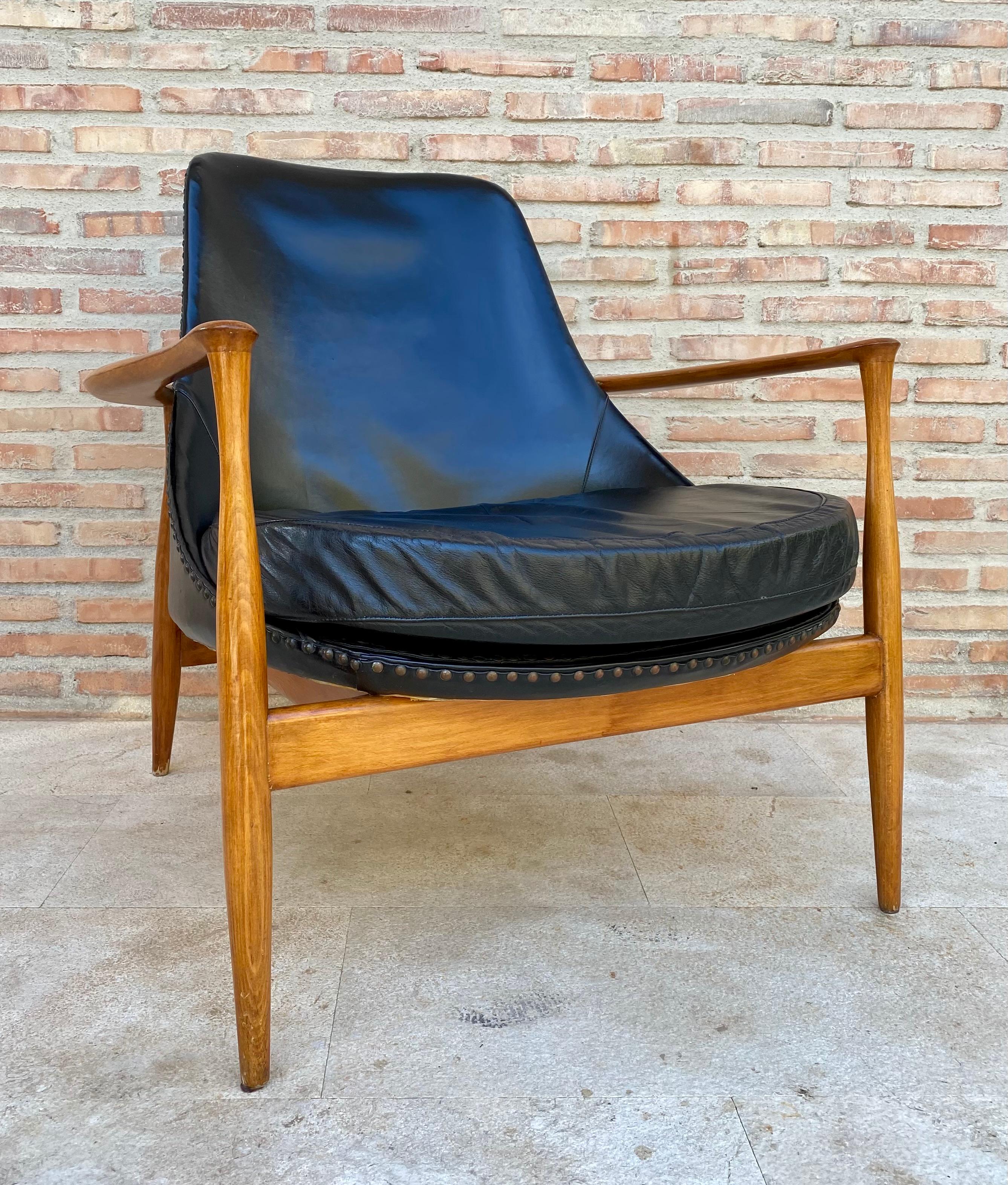 Acclaimed design by Ib Kofod-Larsen, the sculptural wooden frame is sublime. Excellent original finish with minor age wear, original leather upholstery in very good condition. 
This piece is attributed to the mentioned designer/maker. It has no