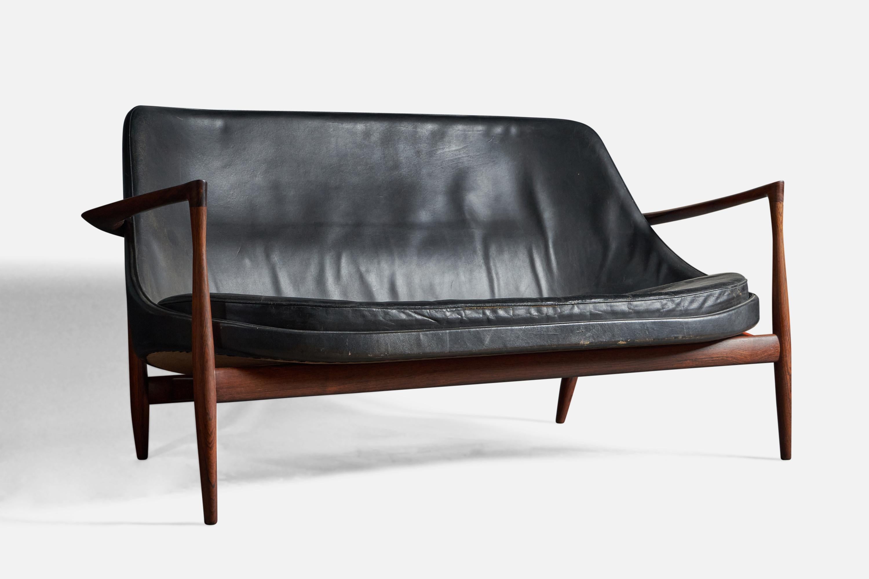 A black leather and rosewood settee, designed by Ib Kofod-Larsen and produced by Christensen & Larsen, Denmark, 1950s.
