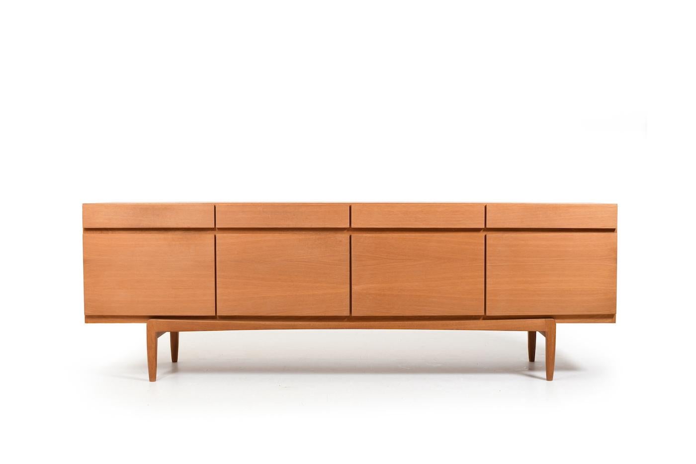 Fine danish sideboard in oak, model FA66 by Ib Kofod-Larsen for Faarup Møbelfabrik Denmark 1963. In front with 4 doors and 4 drawers above. Behind one door with more drawers with green filt. High quality danish production. 1960s.