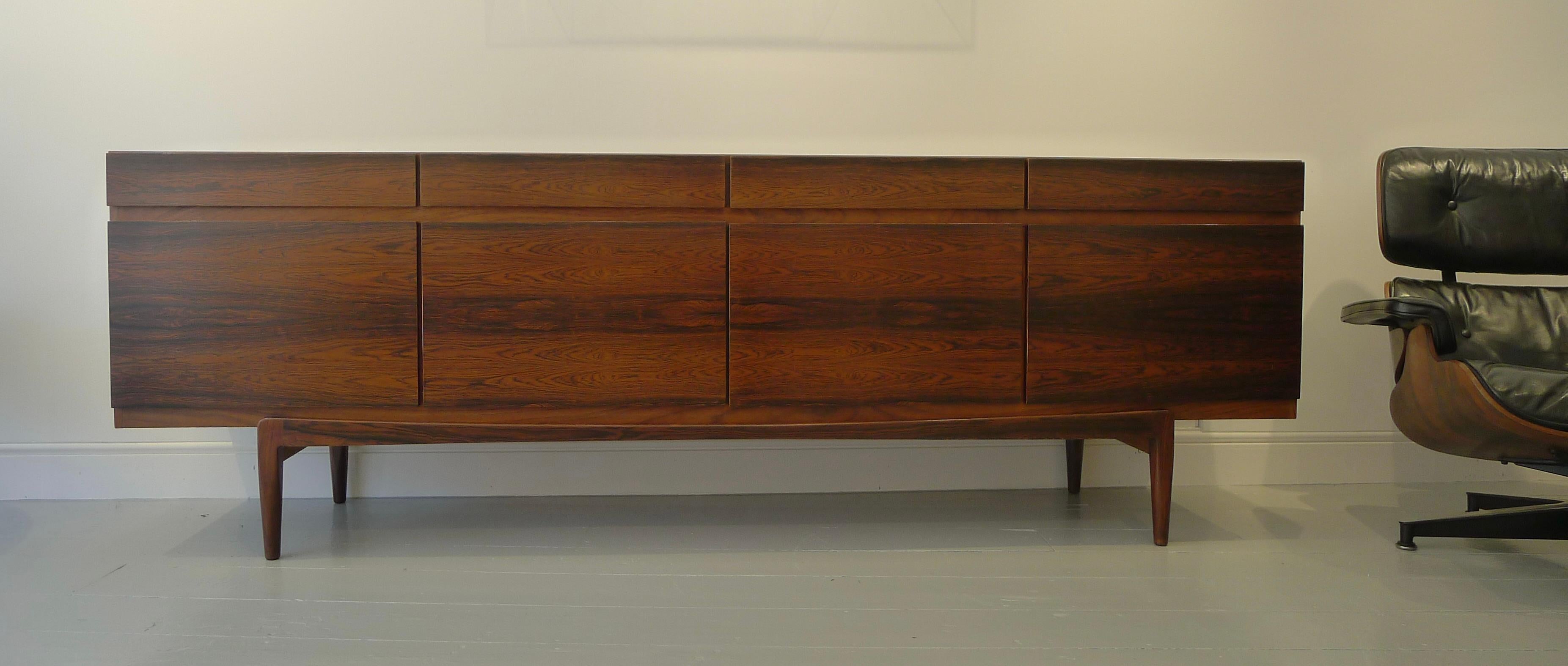 Ib Kofod-Larsen FA-66 Rosewood Sideboard for Faarup Møbelfabrik, Denmark, 1960s

This elegant long sideboard has four drawers to the frieze above four cupboards.  The left cupboard contains five pull-out baize lined trays for cutlery, the other
