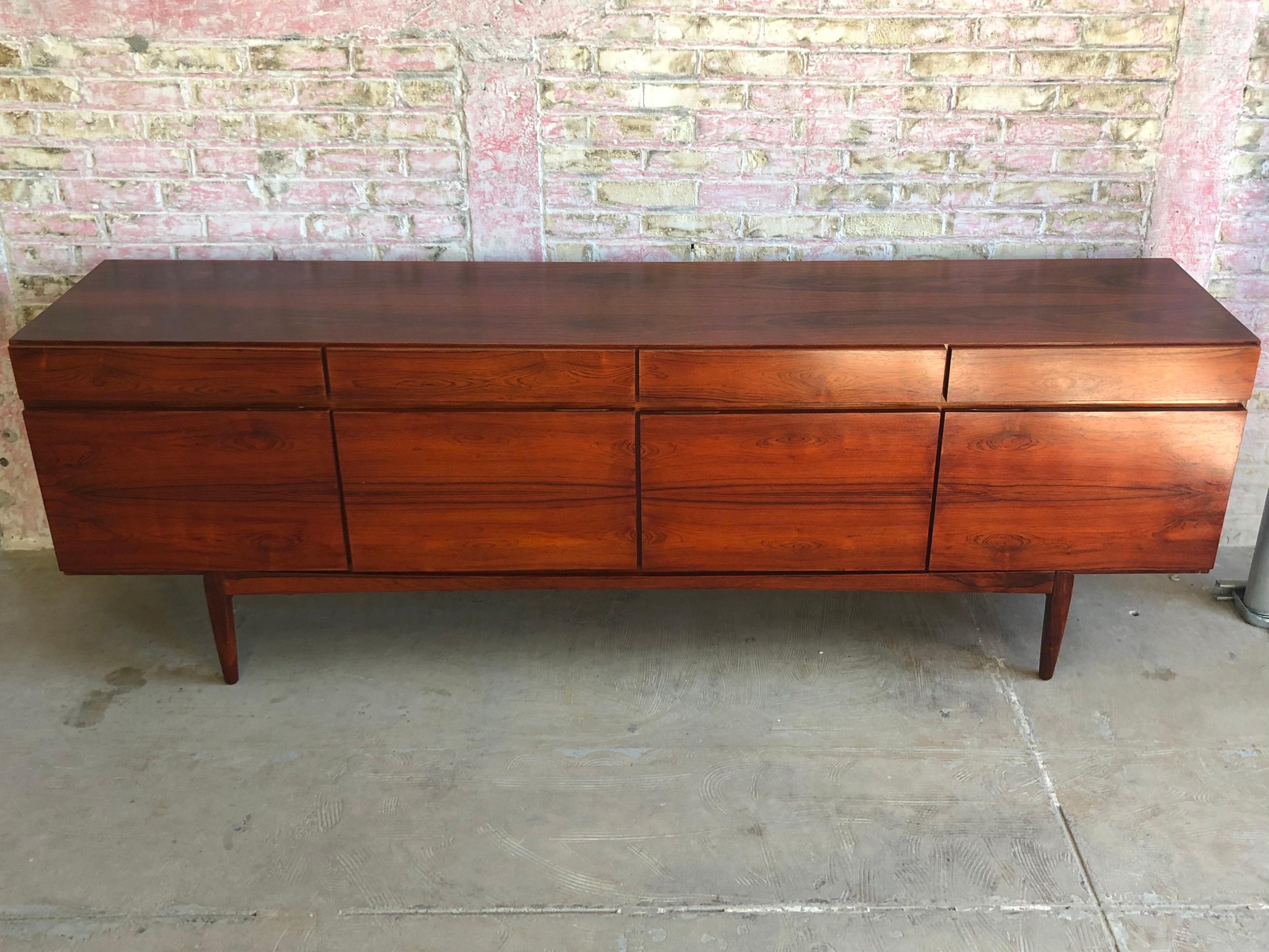 Stunning FA66 Brazilian rosewood credenza designed by Ib Kofod Larsen for Faarup Mobelfabrik, Denmark. This highly collectible Danish piece features a clean-lined design and offers ample storage with a combination of shelves and drawers. As a
