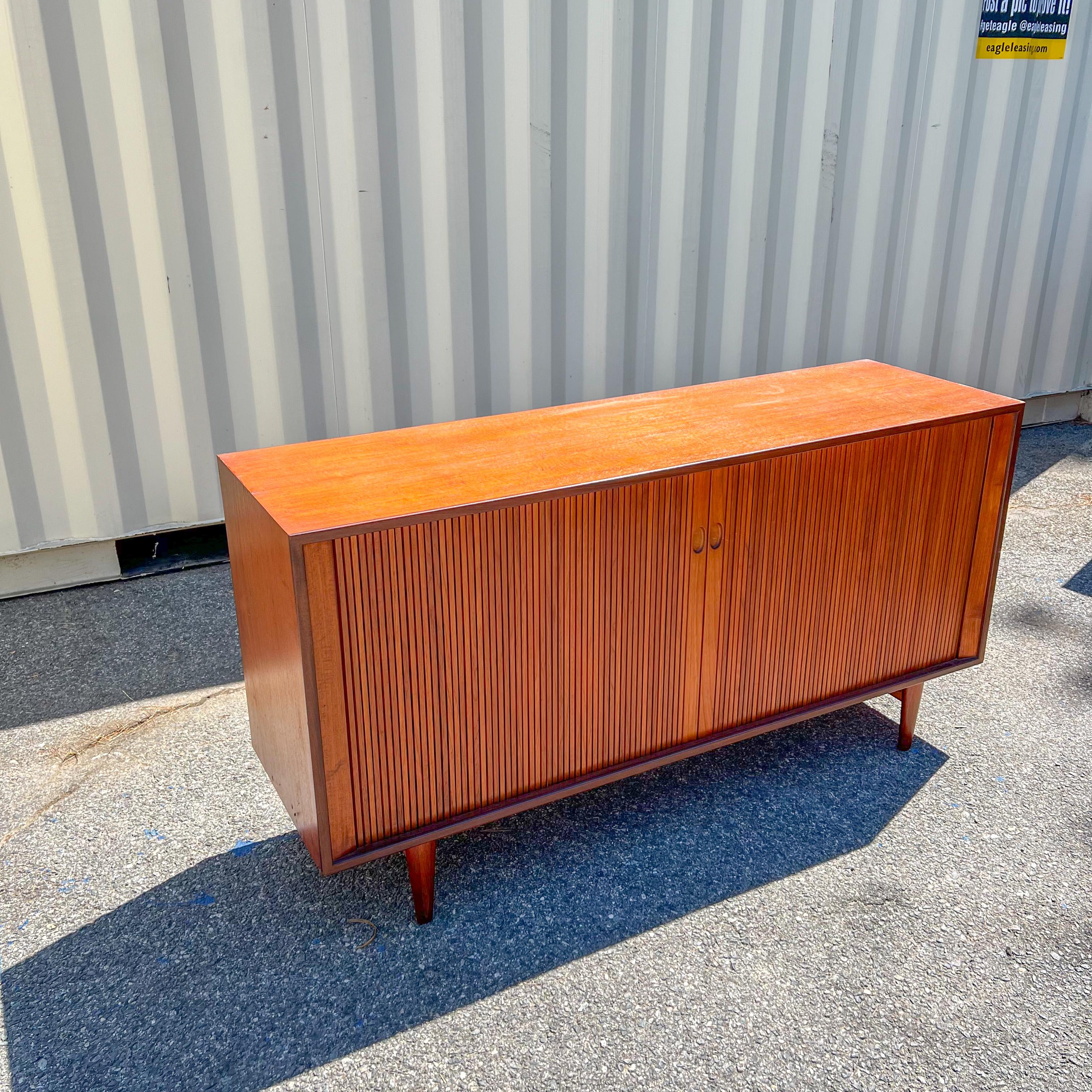 Mid-Century Modern Danish teak credenza with tambour doors and finished back designed by IB Kofod Larsen for Clausen and Sons. Some scuffing/scratching to the teak finish.
