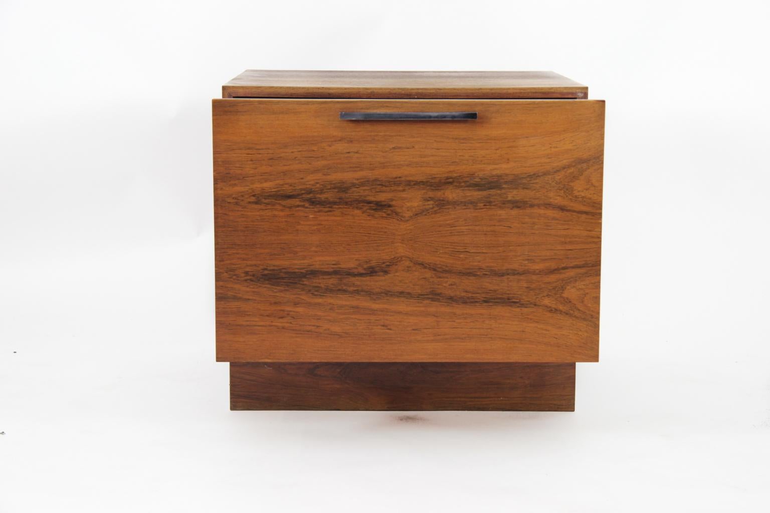 Smart little sideboard, nightstand by Ib Kofod Larsen for Faarup, made in Denmark in the 1960s. Rosewood and rosewood veneer with handles in black metal. 
We have more items in the same serie as this sideboard, also with the black metal