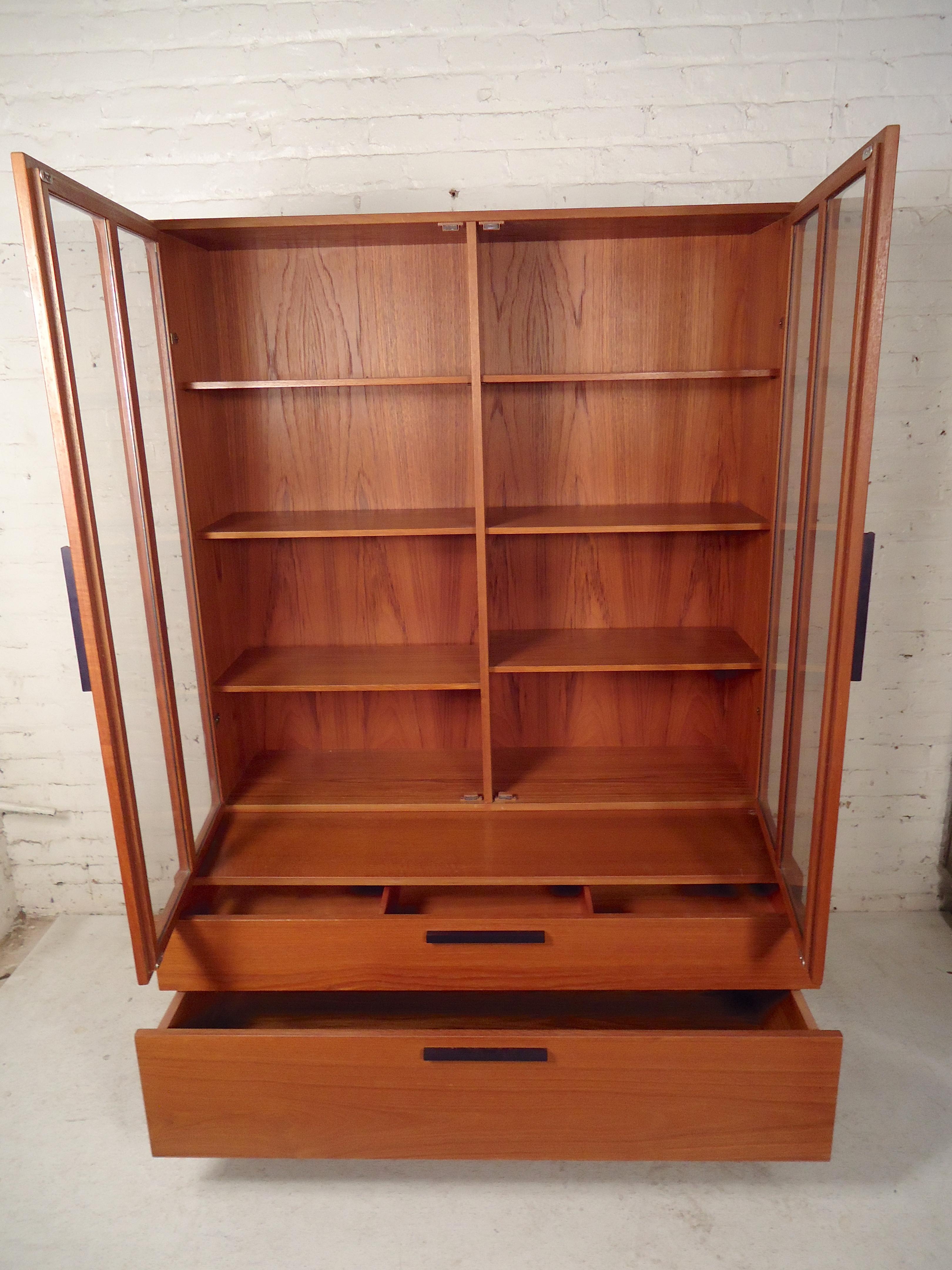 Single two-piece wall unit with bottom wide drawer storage and bookcase topper with glass doors.
Location: Brooklyn NY.
 