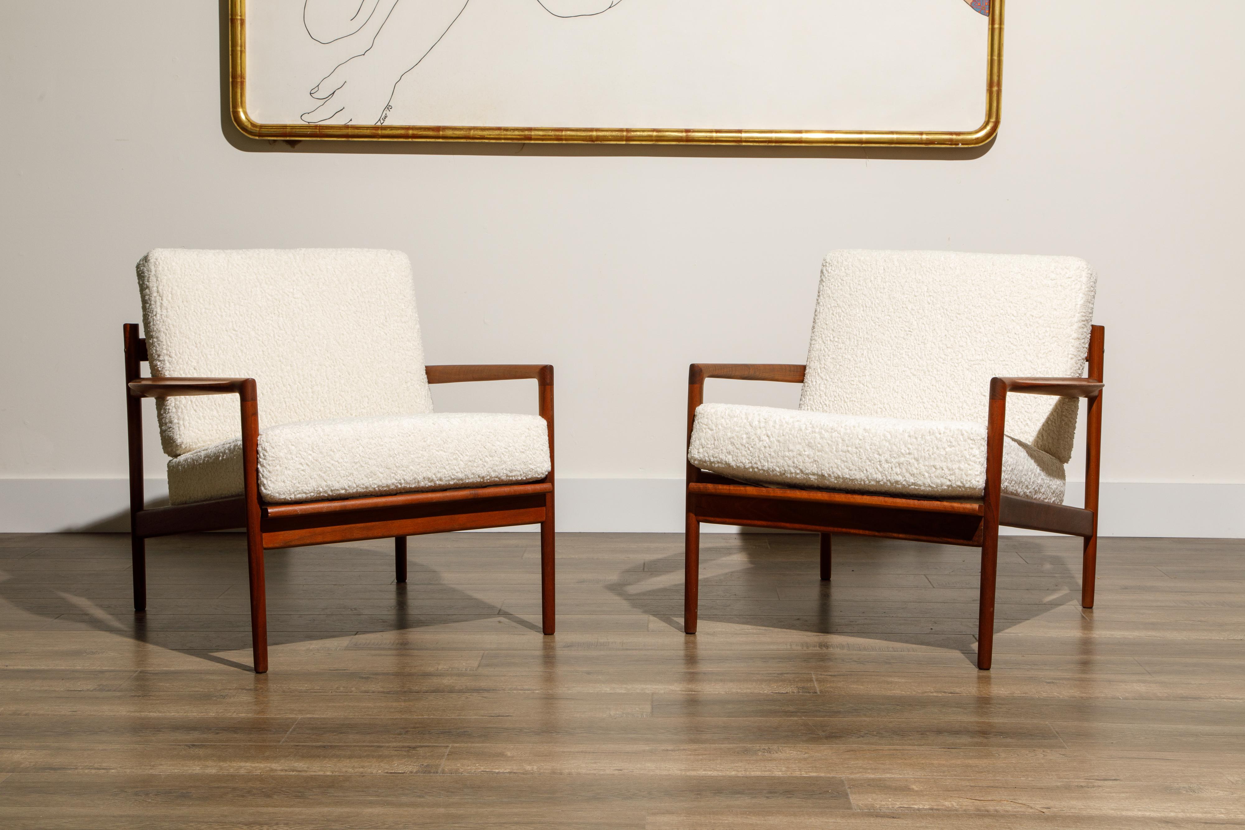 Newly reupholstered in gorgeous white bouclé fabric, this pair of lounge chairs by IB Kofod-Larsen for Selig, circa early 1960s, feature beautiful teak frames with on-trend slatted backs. Incredible designer details abound, from the sculpted arms,