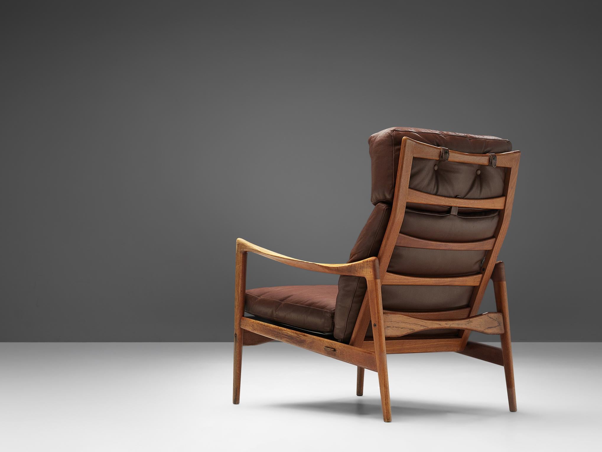 Ib Kofod-Larsen for OPE Möbler, high back chair, in teak and leather, Sweden, circa 1963.

Elegant high back armchair in teak and brown leather upholstery. The frame shows the great skills of Ib Kofod-Larsen. Overall, the chair has graceful lines