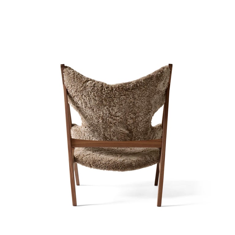 Defined by an exposed, triangular construction, a gently curved seat and back ideally pitched for relaxation, and distinctive cut-outs for resting the elbows when reading (or, of course, knitting), the Knitting Chair affirmed Kofod-Larsen’s