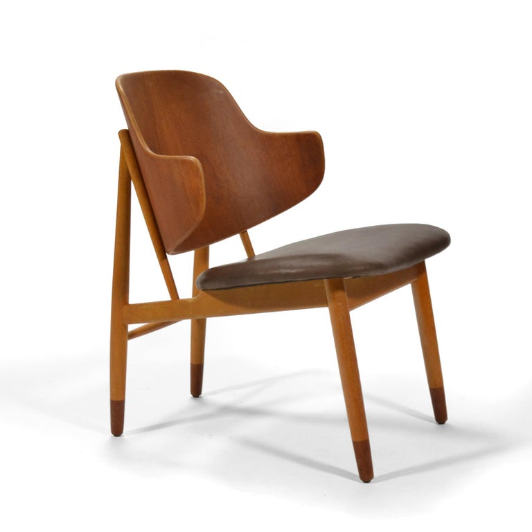 This easy chair designed by Ib Kofod-Larsen for Christiansen & Larsen is very handsome and comfortable with a pleasingly light scale. The contrasting woods accentuate the different components and construction of the design while the leather
