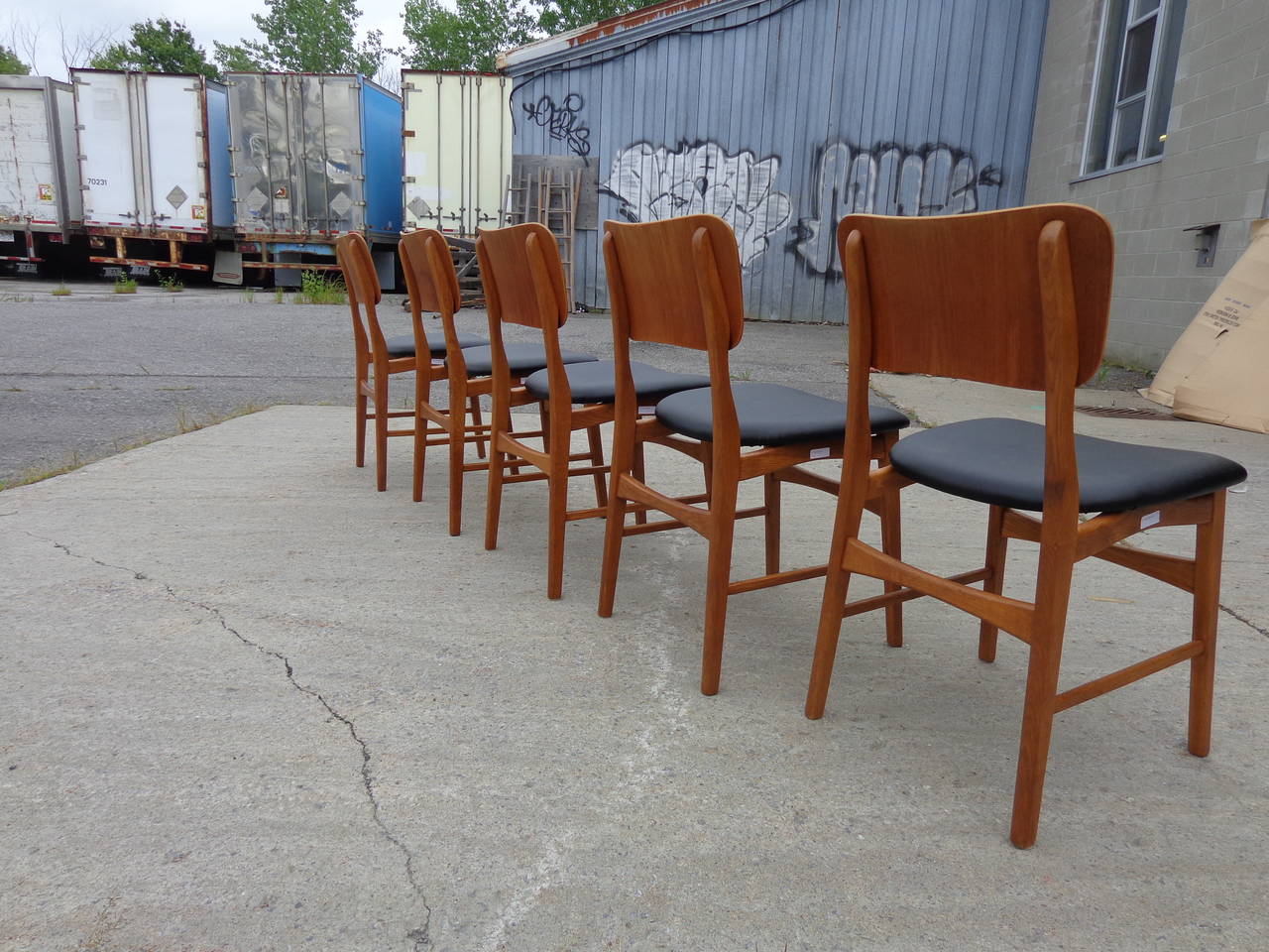 Ib Kofod-Larsen oak frame chair with teak back. Reupholstered in black leatherette.