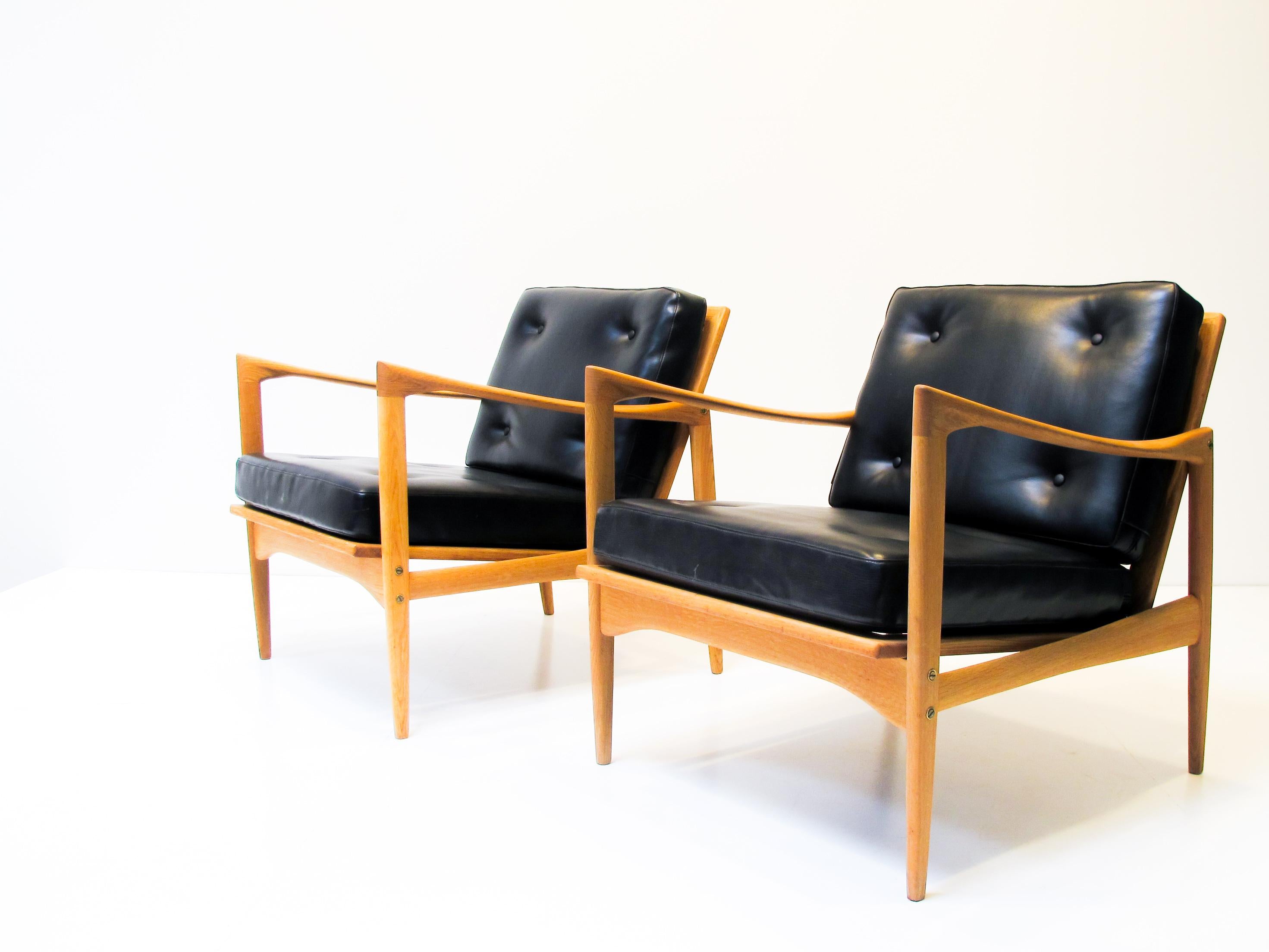 An pair of very rare Kandidaten easy chairs made in oak with brass details and leatherette cushions. 
Designed by Ib Kofod-Larsen for Ope Sweden in the 1960s. 

It´s possible to side order new upholstery with Hallingdal 