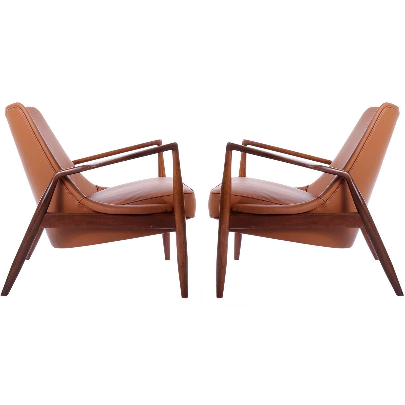 A stunning pair of Sälen (engl. Seal) easy chairs in solid teak and wonderful cognac leather, designed by Ib Kofod Larsen, manufactured by OPE Sweden in midcentury, circa 1956. 
This extremely rare model will be offered as set of two. Both chairs