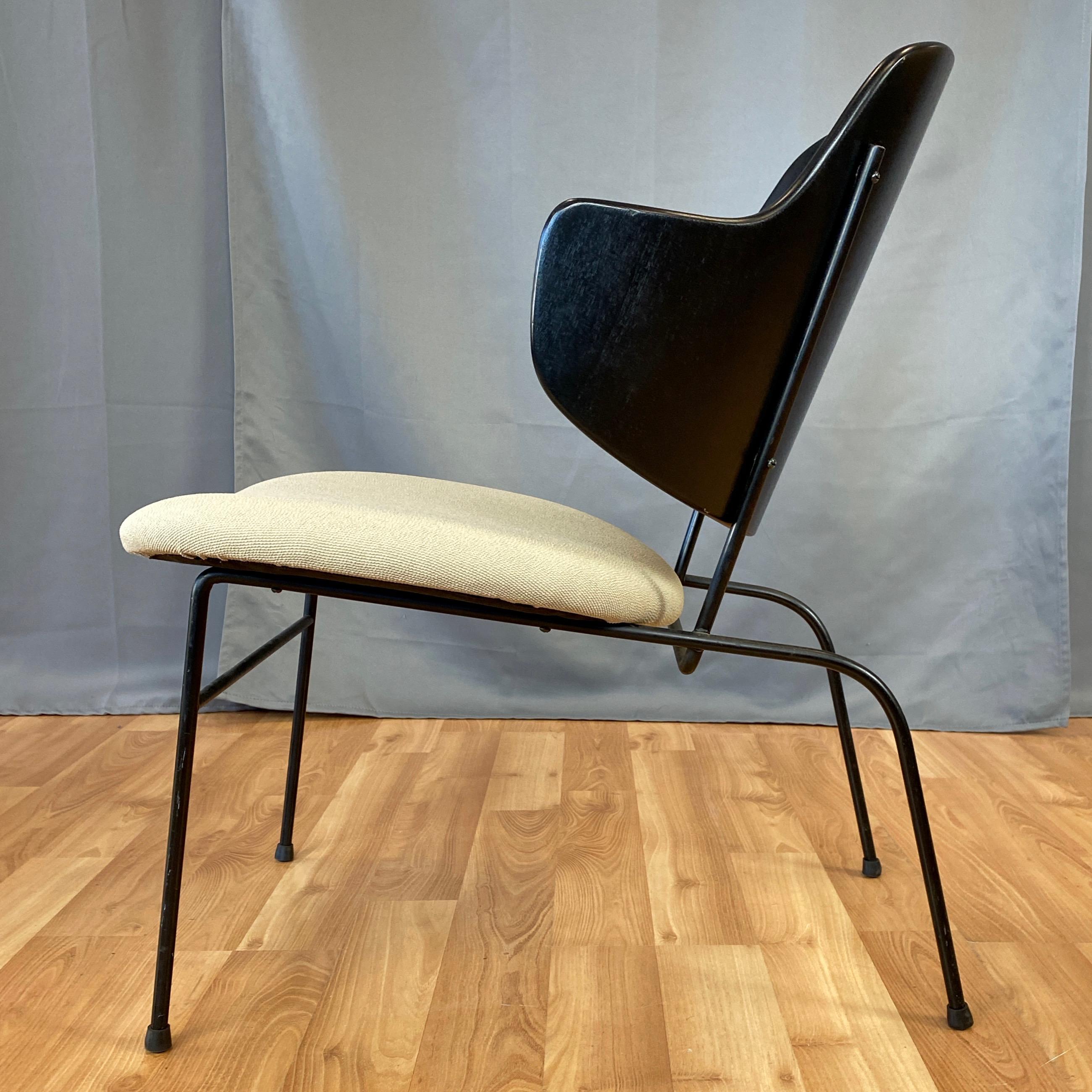 A rare 1950s lower and wider version of Ib Kofod-Larsen’s iconic Penguin lounge chair with newly upholstered seat.

Iron rod frame in original satin black finish features extended back legs that give the piece a strikingly handsome stance. Further