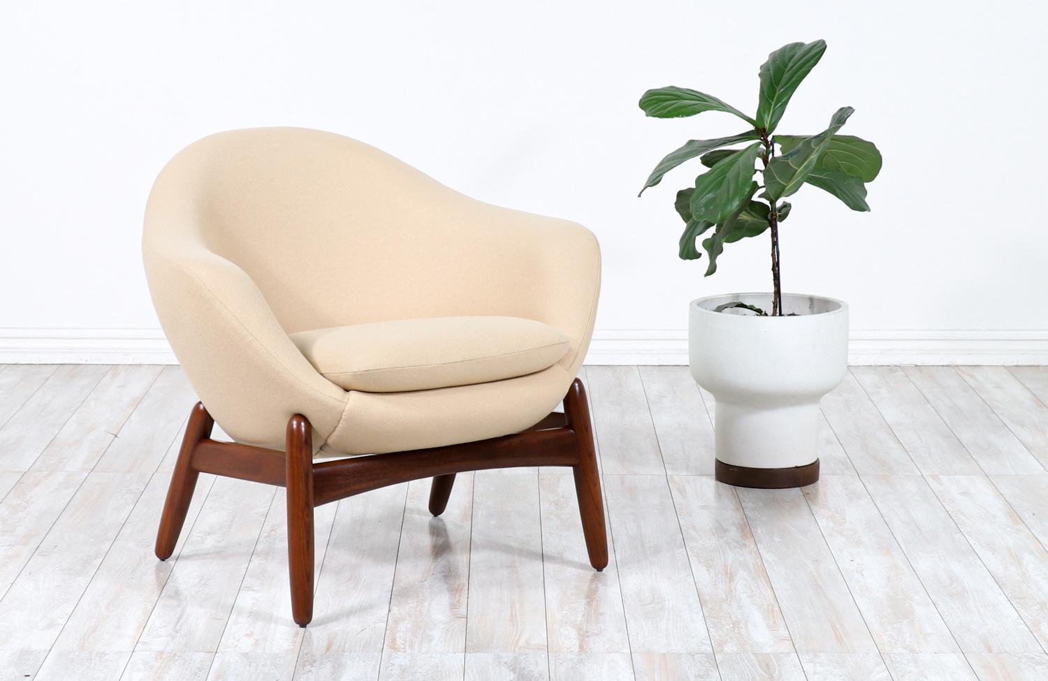 Loung chair designed by Ib Kofod Larsen for cabinetmaker Povl Dinesen in Denmark circa 1950’s. This fantastic rare “Pod” design by Larsen features an Afomosia teak frame with angled conical legs. The pod, which appears to float upon the base, is