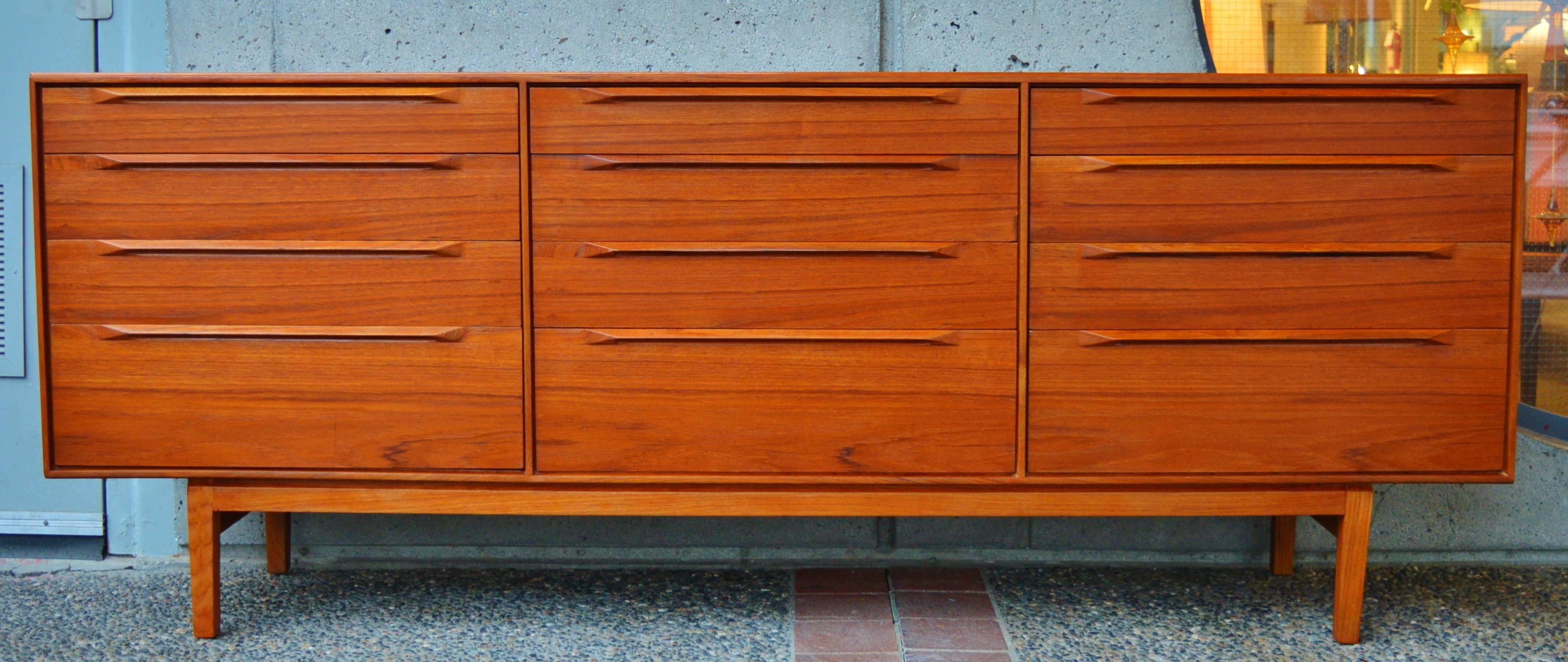This exquisite Danish modern teak dresser is top quality, with all wood construction and impeccable detailing. Rare to see the 12 drawer version, the top drawers are slimmest, each with two dividers that are adjustable or removable - perfect for