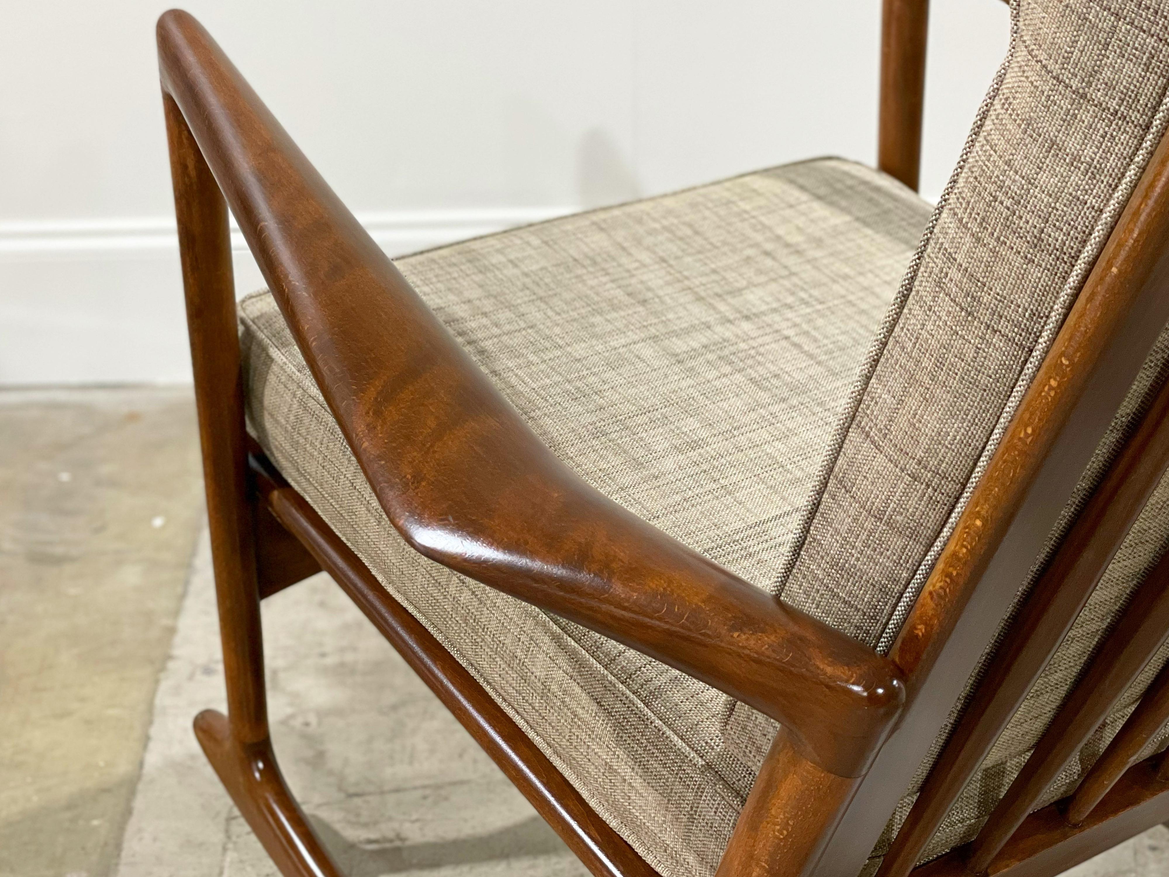 Iconic sculpted Mid-Century Modern rocking chair by Ib Kofod Larsen for Selig. A remarkable example of one of Larsen's best designs. Sculpted walnut stained solid beechwood frame is immaculate - finished in a gorgeous semigloss lacquer. Freshly