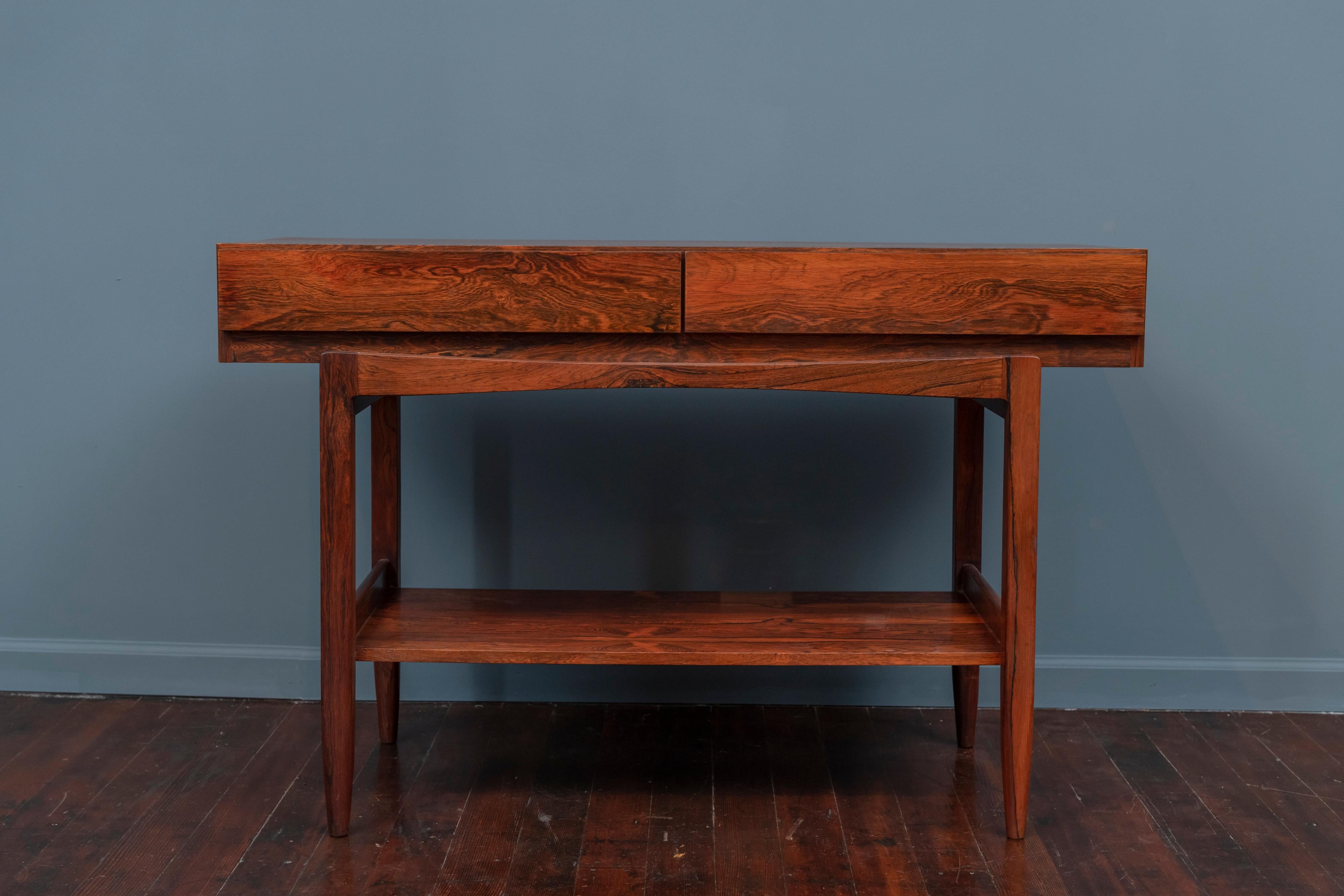 Ib Kofod-Larsen design rosewood console table for Faarup, Denmark. Newly refinished rosewood veneer console table with dramatic cathedrals, two drawers and an elegant Minimalist design.