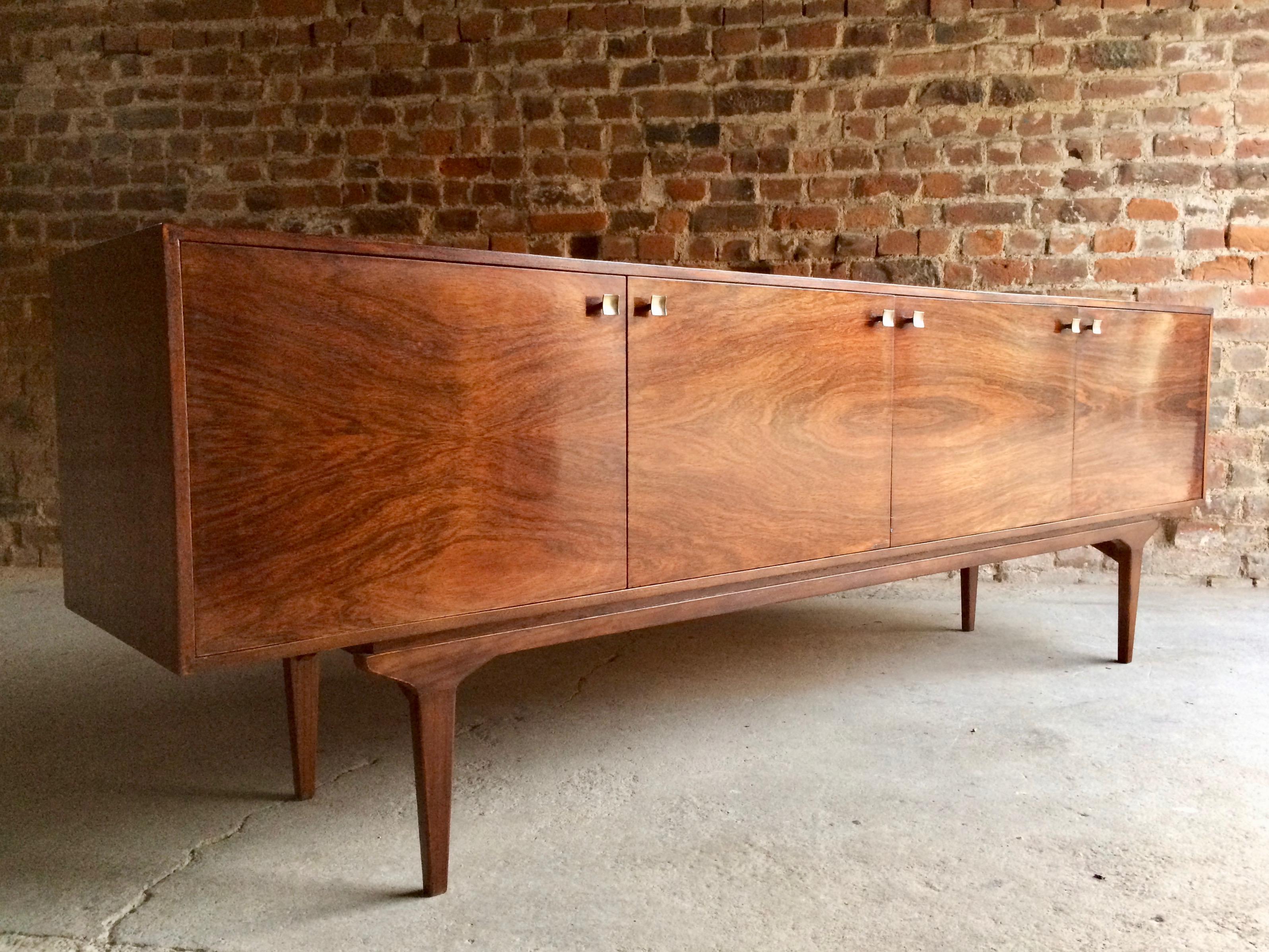 Magnificent midcentury beautifully long and low Ib Kofod-Larsen rosewood credenza sideboard designed for Everest furniture, circa 1960s, the fabulous grained rectangular top over four cupboard doors, all with original pull-out trays and shelves, all