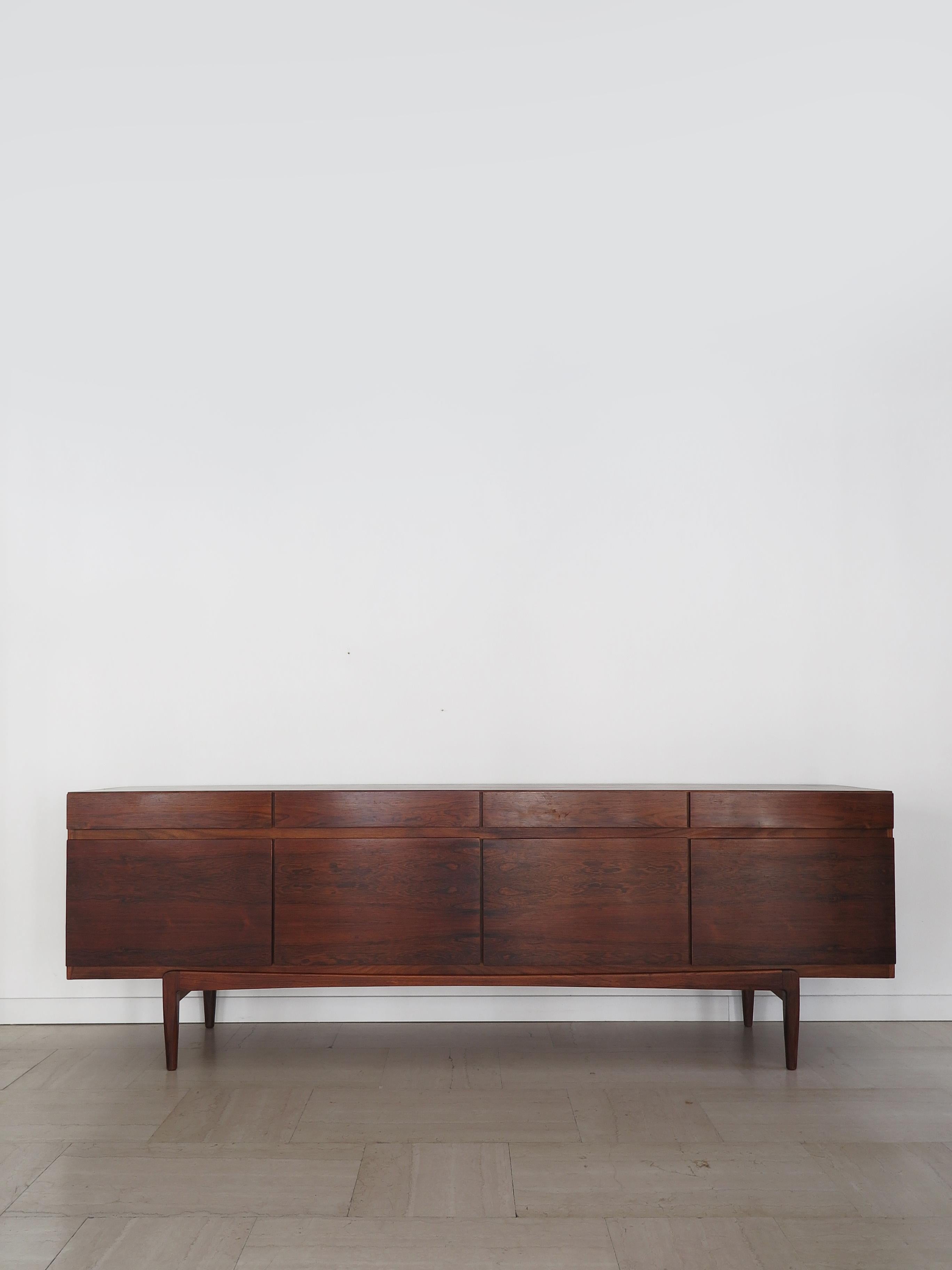 Aparador escandinavo de diseño moderno de mediados de siglo, de madera oscura, diseñado por el artista danés Ib Kofod-Larsen para Faarup Møbelfabrik, con 4 cajones, 4 puertas y 5 cajones extraíbles en el interior de la primera puerta y etiqueta