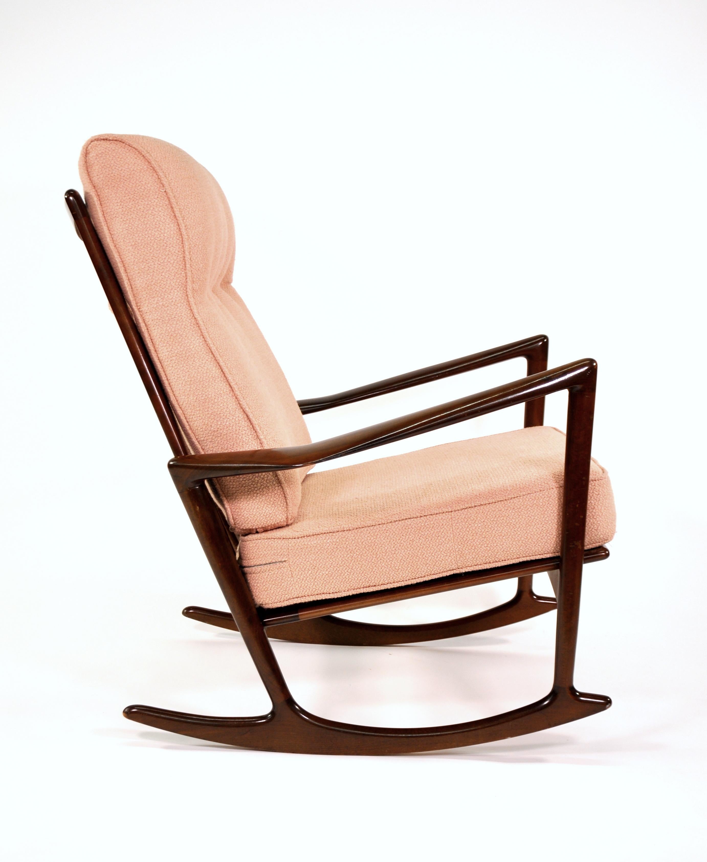 Rare Mid-Century Modern rocking chair, model 650-15, designed by Ib Kofod-Larsen for Selig in Denmark, circa 1960s. This elegant rocker has a walnut-stained beechwood frame with an open back and sculpted armrests creating a gorgeous modern profile.