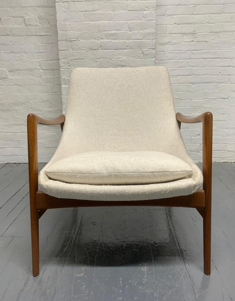 Danish modern, Ib Kofod-Larsen style lounge chair. The chair has a teak frame with an off-white upholstery. 
Nice chair for a Mid-Century Modern interior.