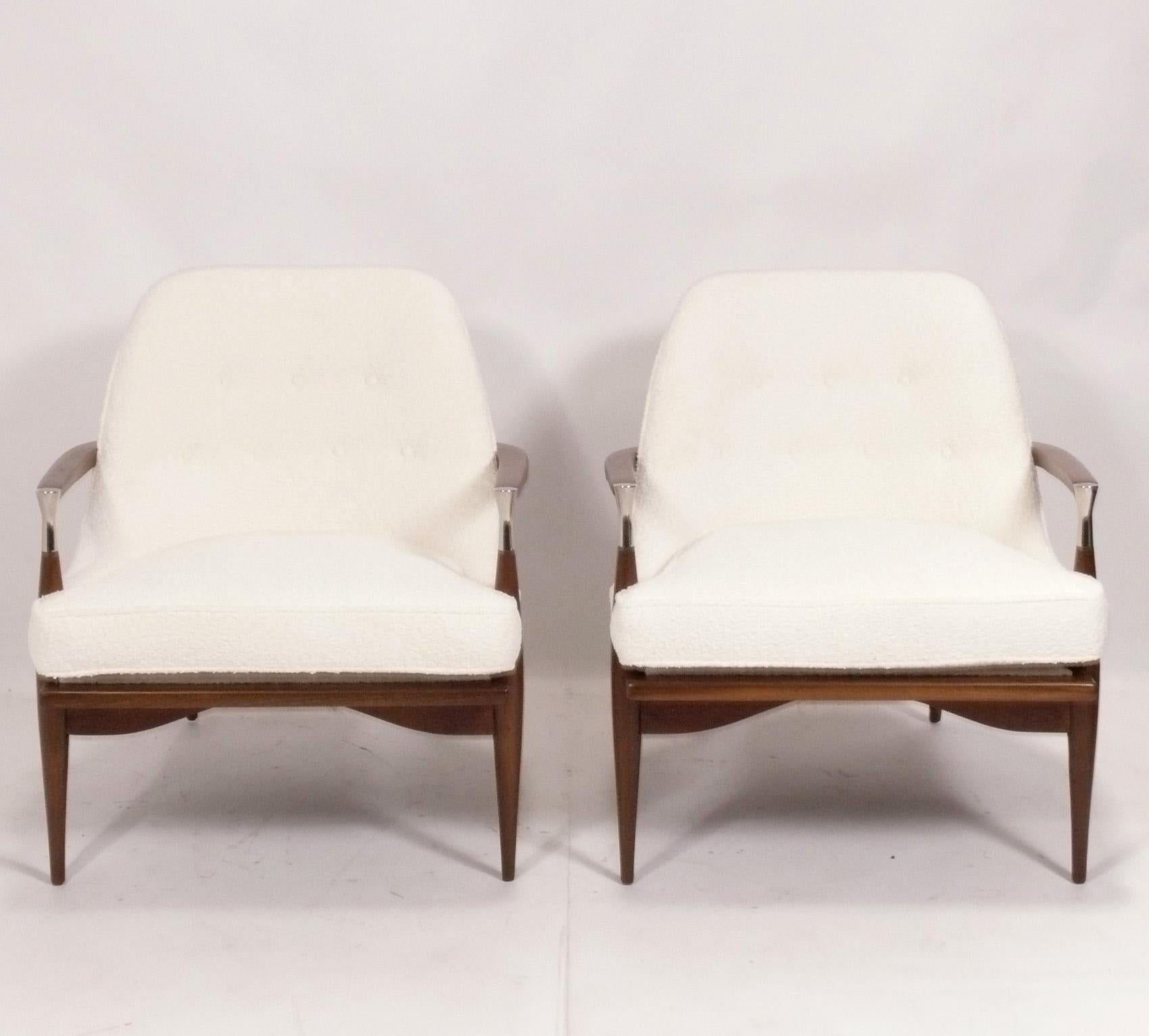 Pair of Danish Modern Lounge Chairs, in the style of Ib Kofod Larsen, Denmark, circa 1960s. They have been completely restored with the walnut frames refinished and reupholstered with new foam and ivory boucle fabric. 