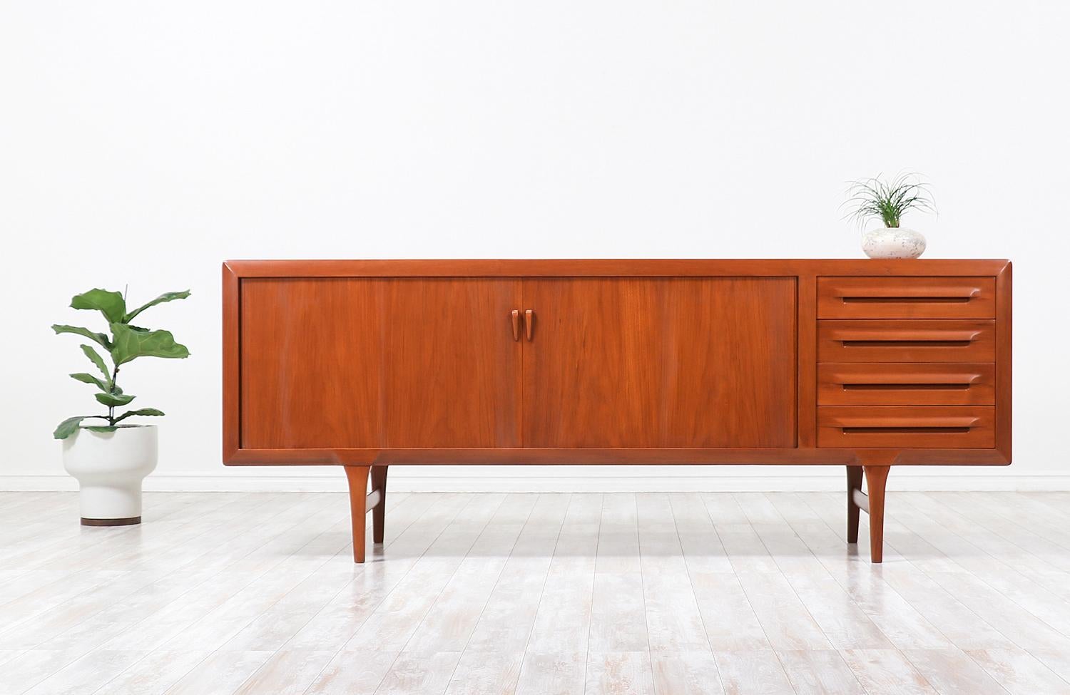 Tambour door credenza designed by Ib-Kofod Larsen for Faarup Møbelfabrik in Denmark, circa 1950s. Impeccably crafted in teak wood, this beautiful credenza shows an intricate wood grain throughout and features smoothly functioning tambour doors that