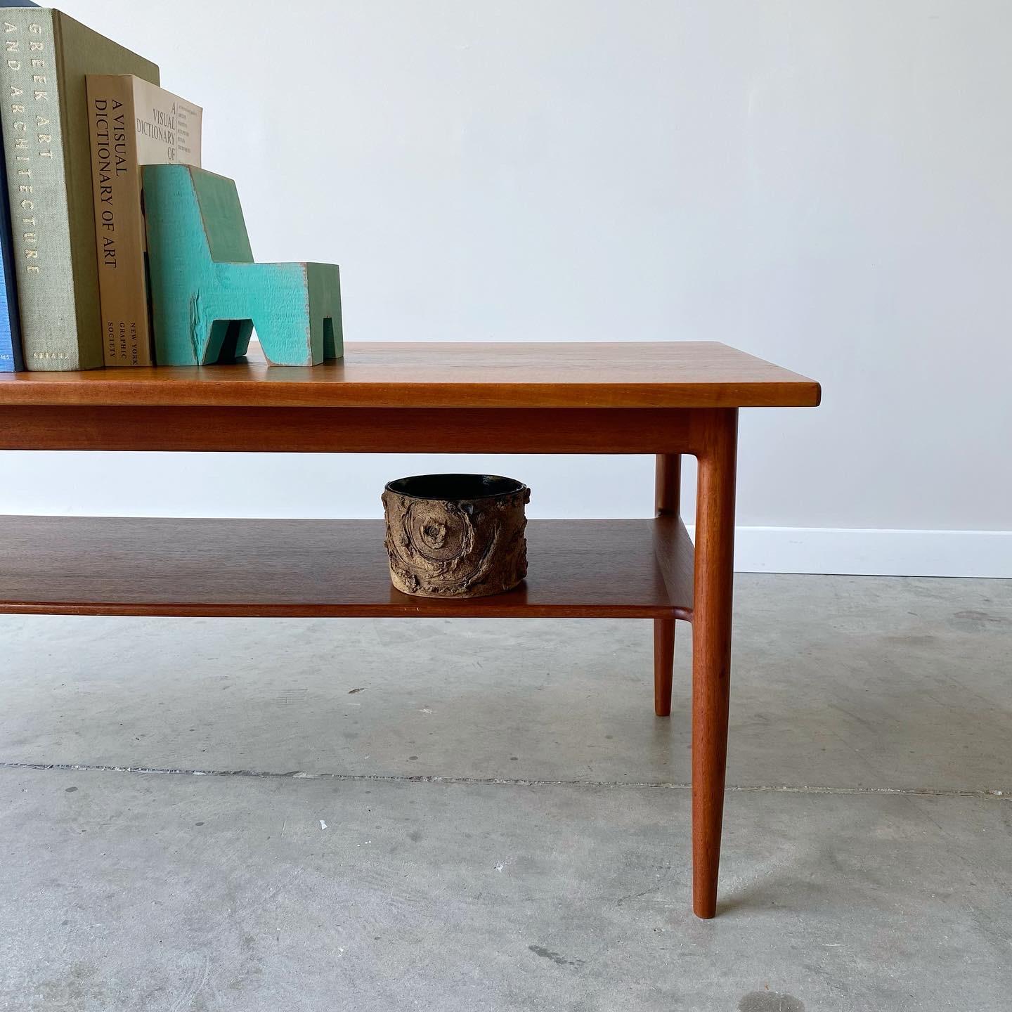 Simple yet stunning sculptural form to this Danish modern teak coffee table.  Designed by Kofod-Larsen and produced by Christensen and Larsen in the 1960s.  
