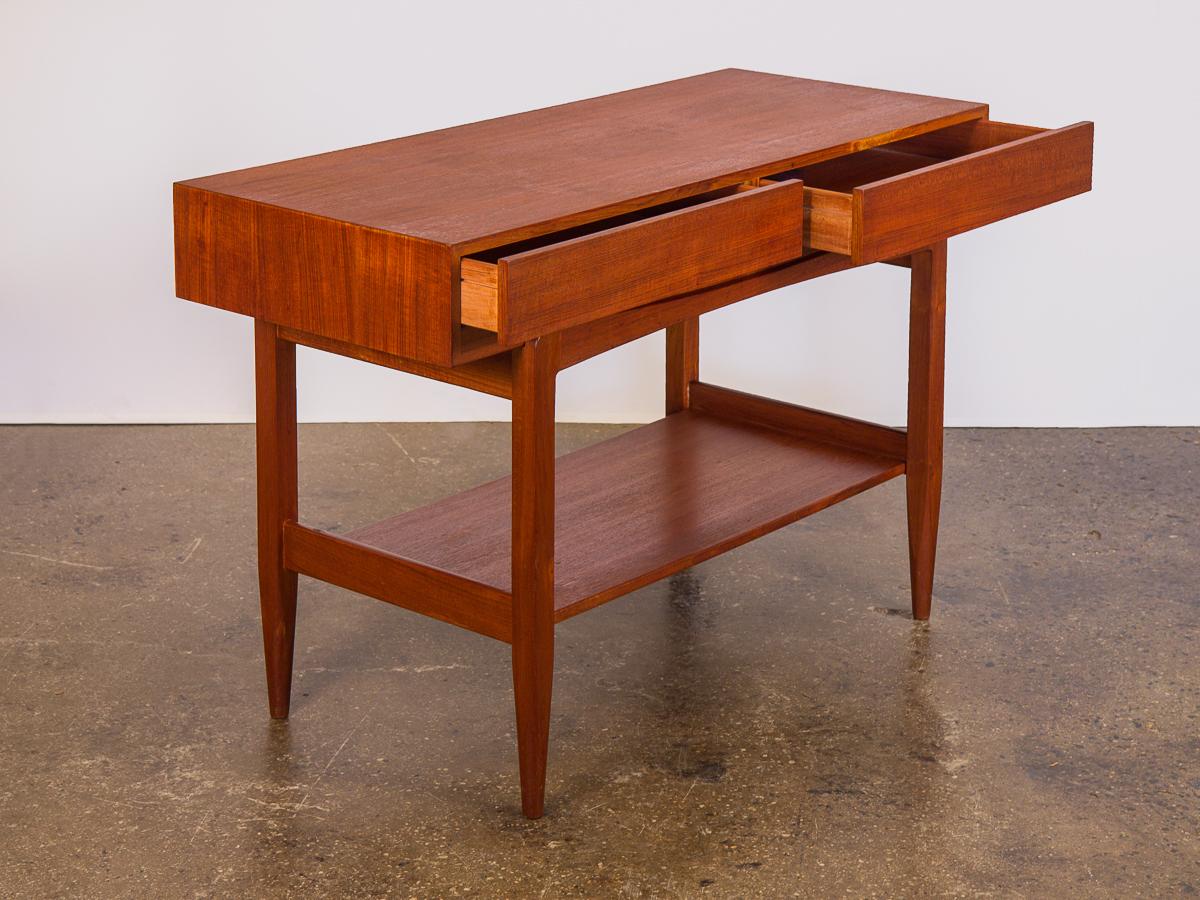 1960s Ib Kofod-Larsen teak console table for Faarup Mobelfabrik. Highly functional and versatile. Beautiful floating console table has two drawers for storage. Minimal lines follow through to the elegantly tapered legs. In excellent condition, with