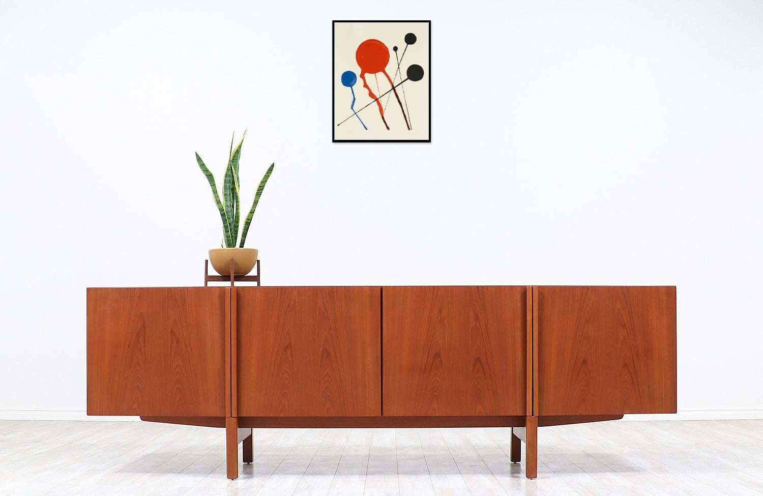Minimalist credenza designed by Ib-Kofod Larsen in collaboration with the workshop of Faarup Møbelfabrik in Denmark circa 1950s. Impeccably crafted in teak wood, this beautiful credenza shows an intricate wood grain throughout and features smoothly