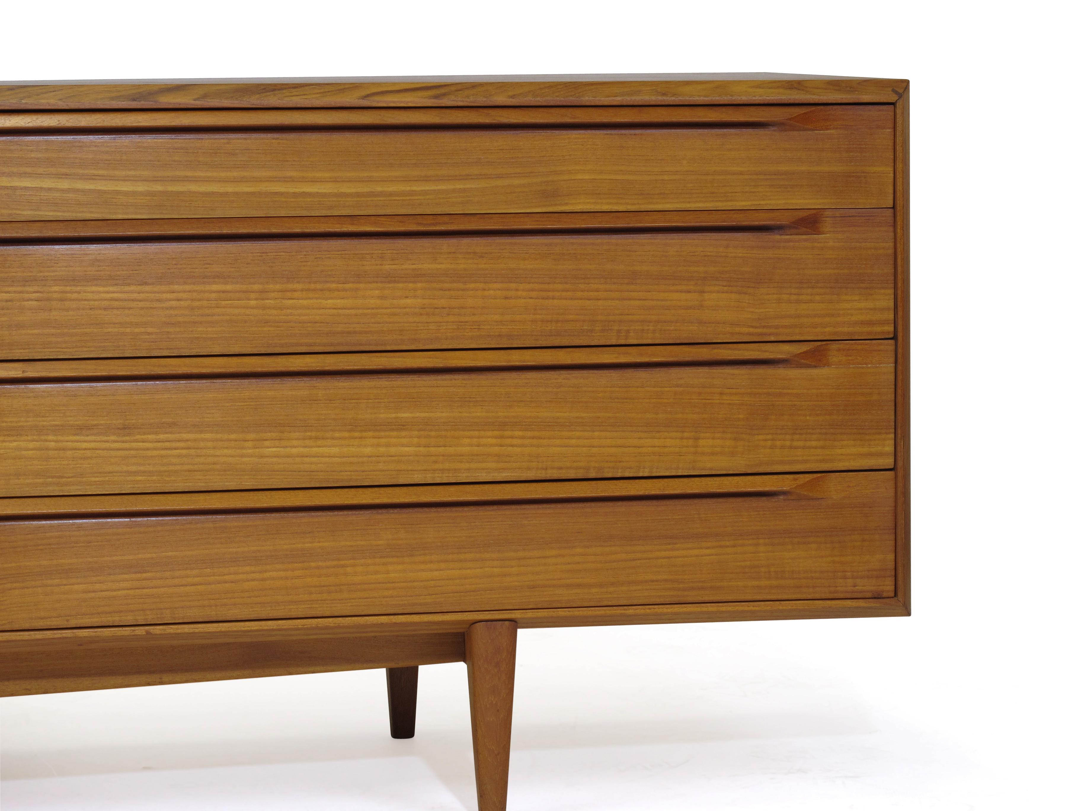 Teak dresser designed by IB Kofoed Larsen for Fredericia Moblefabrik model 249, circa 1960 Denmark. Dresser crafted of teak with finely mitered edges and eight drawers with sculpted hand pulls, raised on solid teak base and legs.