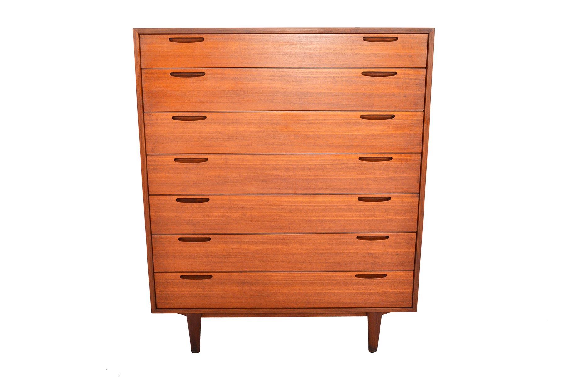 This gorgeous Danish modern seven-drawer midcentury teak highboy dresser was designed by Ib Kofod- Larsen for Brande Møbelfabrik in the 1960s. Rich woodgrain and high quality construction define this Classic piece. Each drawer features two carved
