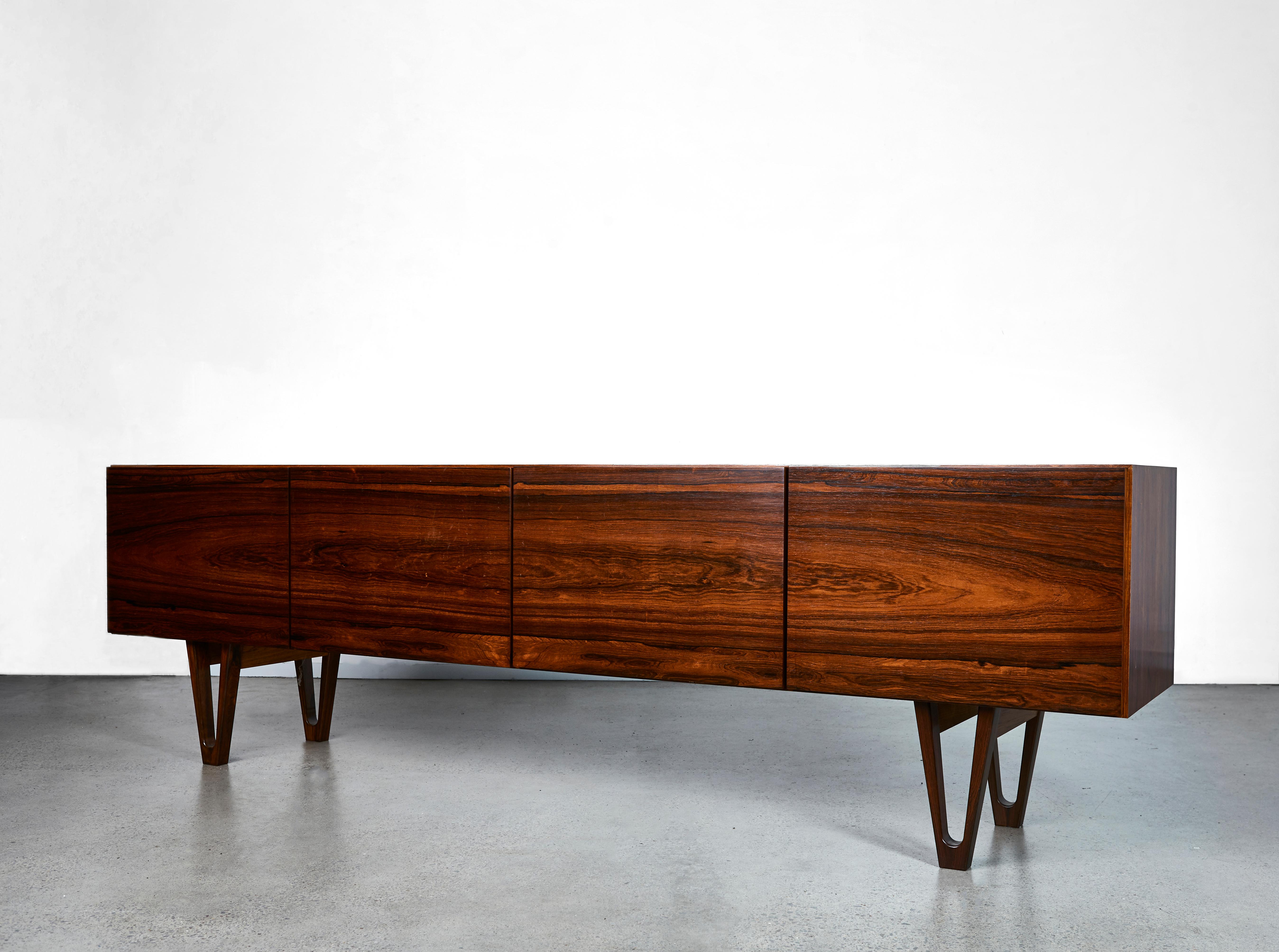 Stunning rosewood sideboard by Ib Kofod Larsen for the Swedish firm Seffle Möbelfabrik, made in the late 1950s. Low design that gives the impression that the sideboard is extra long. Beautifully sculpted legs and carefully hollowed out discreet