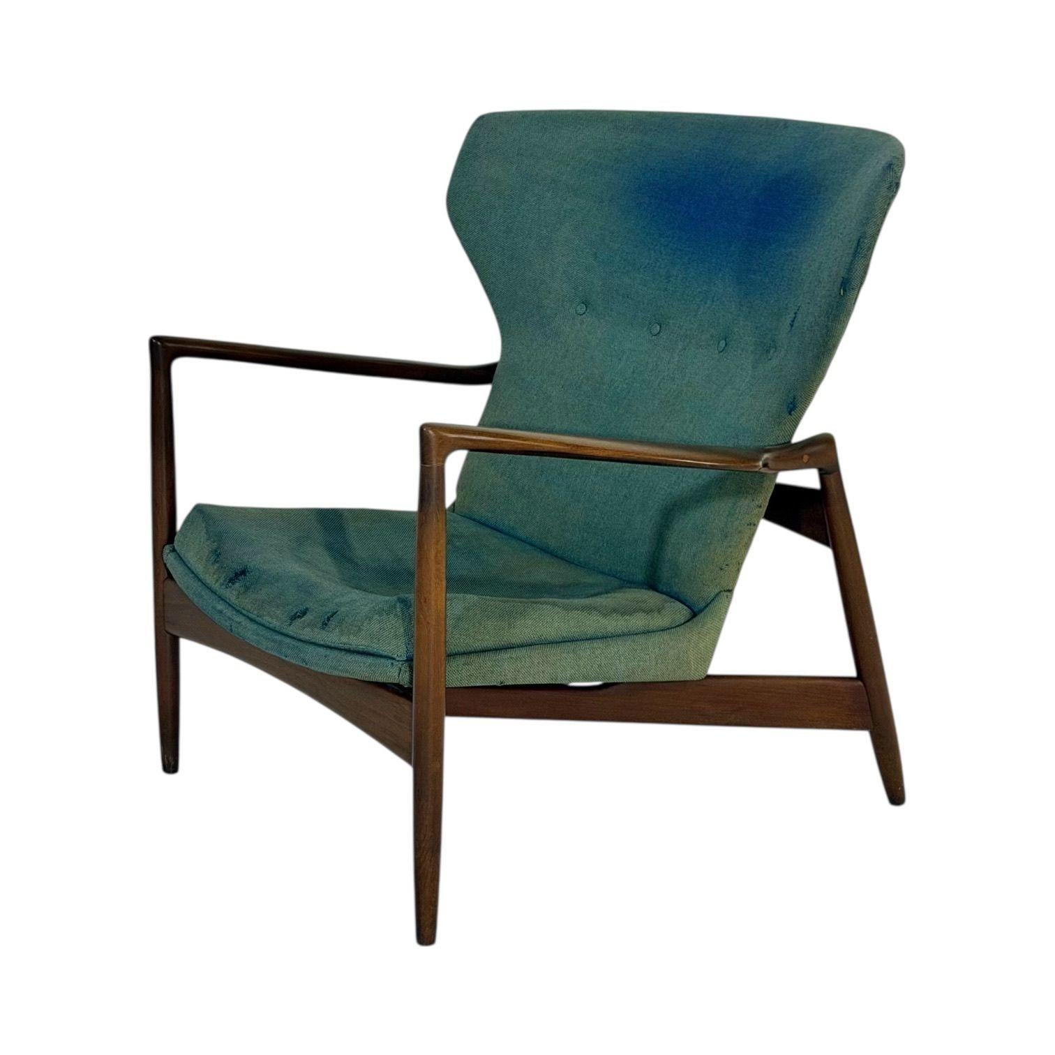 IB Kofod-Larsen Wingback Lounge Chair, Danemark, années 1950.  La sellerie d'origine présente des signes d'usure liés à l'âge et à l'utilisation.
Mesure 32