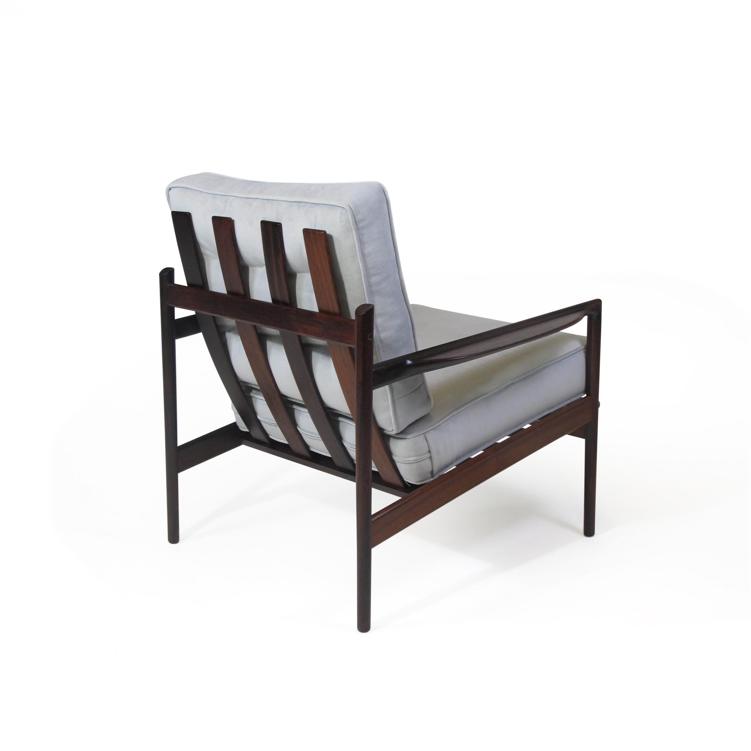 Pair of Mid Century Brazilian Rosewood lounge designed by IB Kofoed Larsen for Selig. Each lounge chair is crafted of solid Brazilian rosewood with rich dynamic-grain, sculpted armrests, slatted backrest, with loose cushions upholstered in a soft