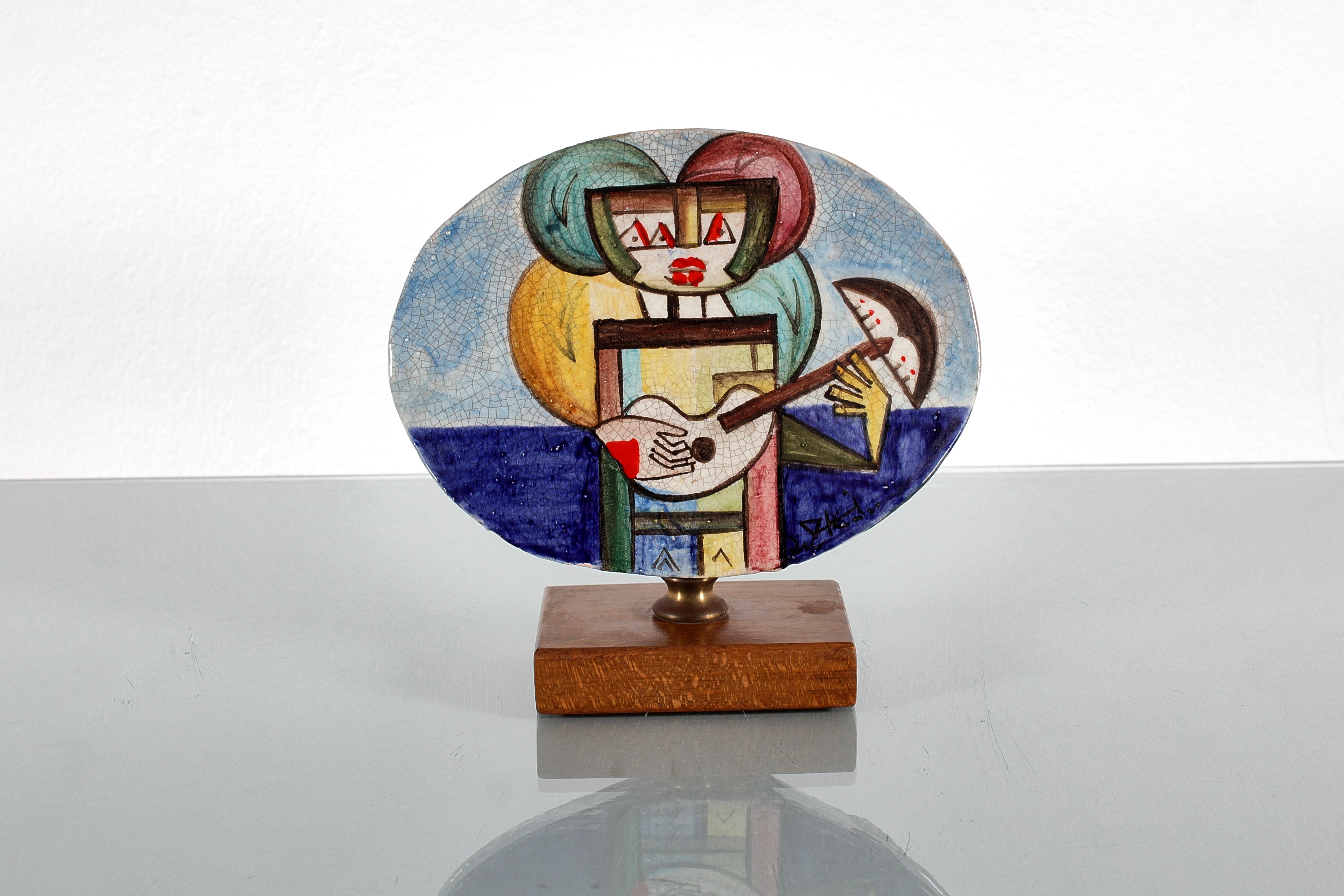Ibrahim Shaban Likmetaj Kodra (Ishëm 1918 - Mailand 2006) für Ceramiche Rossicone, 70er Jahre Italien.
Polychrome Keramikskulptur mit Craquelé-Effekt, verankert mit einem Messingelement auf einem Holzsockel. Signatur von Ibrahim Kodra, vorne rechts