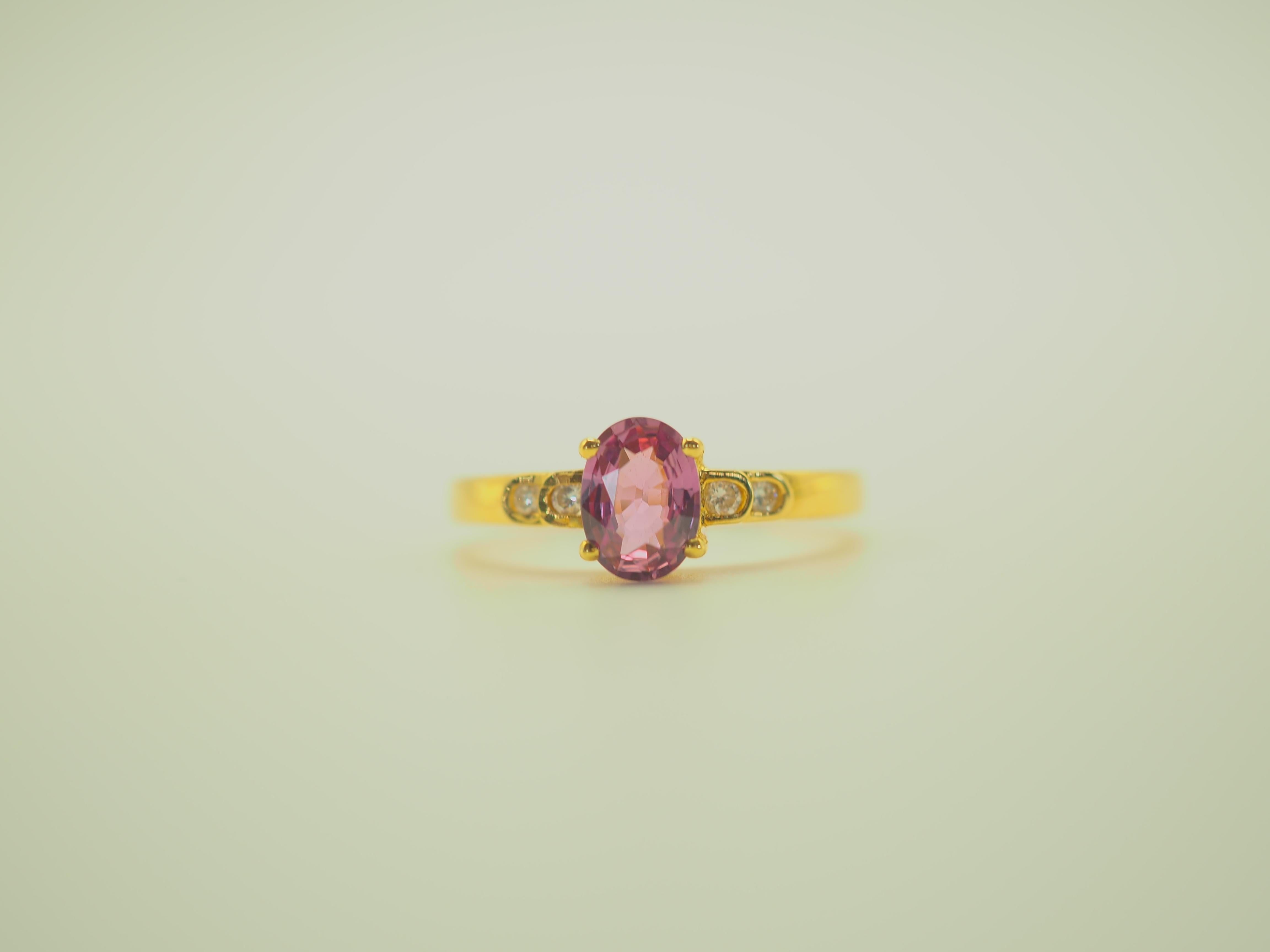 Fine dainty and precious engagement ring in 18k solid yellow gold. The main gemstone is the rare and prized pink colored oval sapphire, flawless and highly saturated. The diamonds are 4 stones and is very clear, bright and lively which adds to the