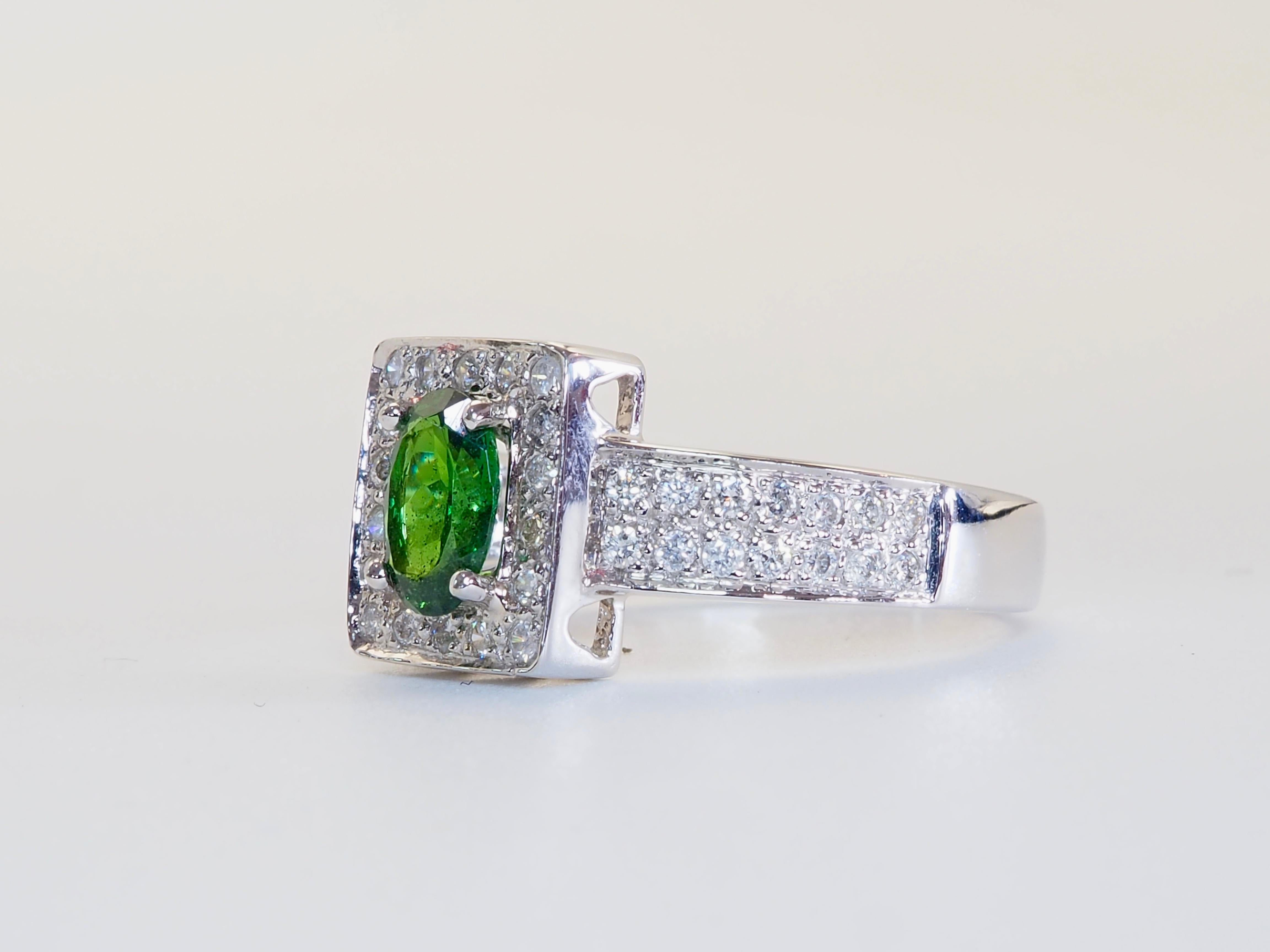 Luminosa celebrazione di colori rari e raffinata maestria, questo anello da cocktail con incastonatura a raggiera mette in mostra un granato Tsavorite dal taglio ovale di 0,71ct, certificato non trattato dall'ICA GemLab. La tonalità verde del