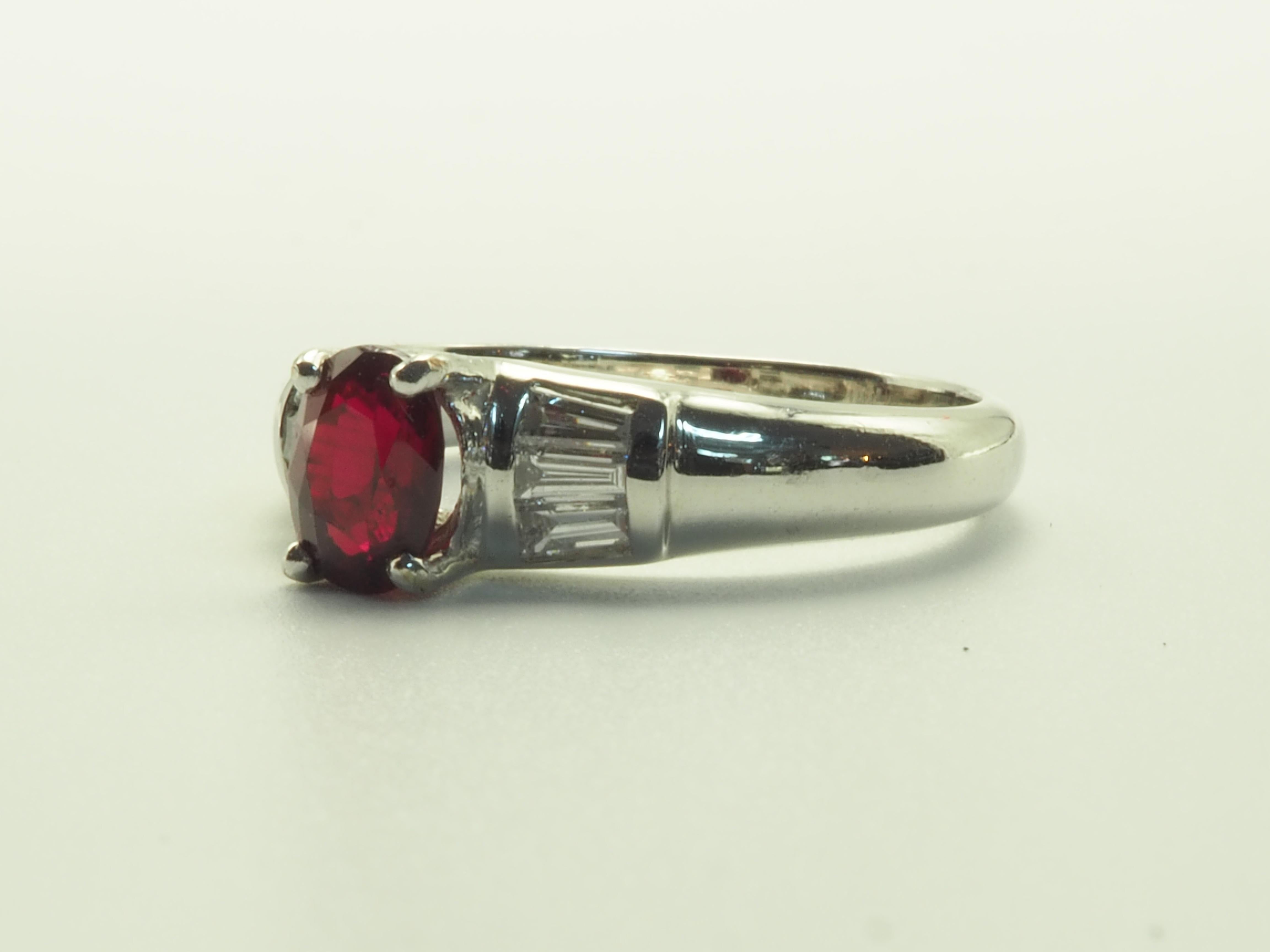 This amazing cocktail ring boasts premium oval cut ruby of 0.98 carats. The stunning oval cut ruby is of vivid red color with natural inclusions, but the fire is lively. 

 There are 6 tapered diamonds in total, all totaling to 0.30 carats. The