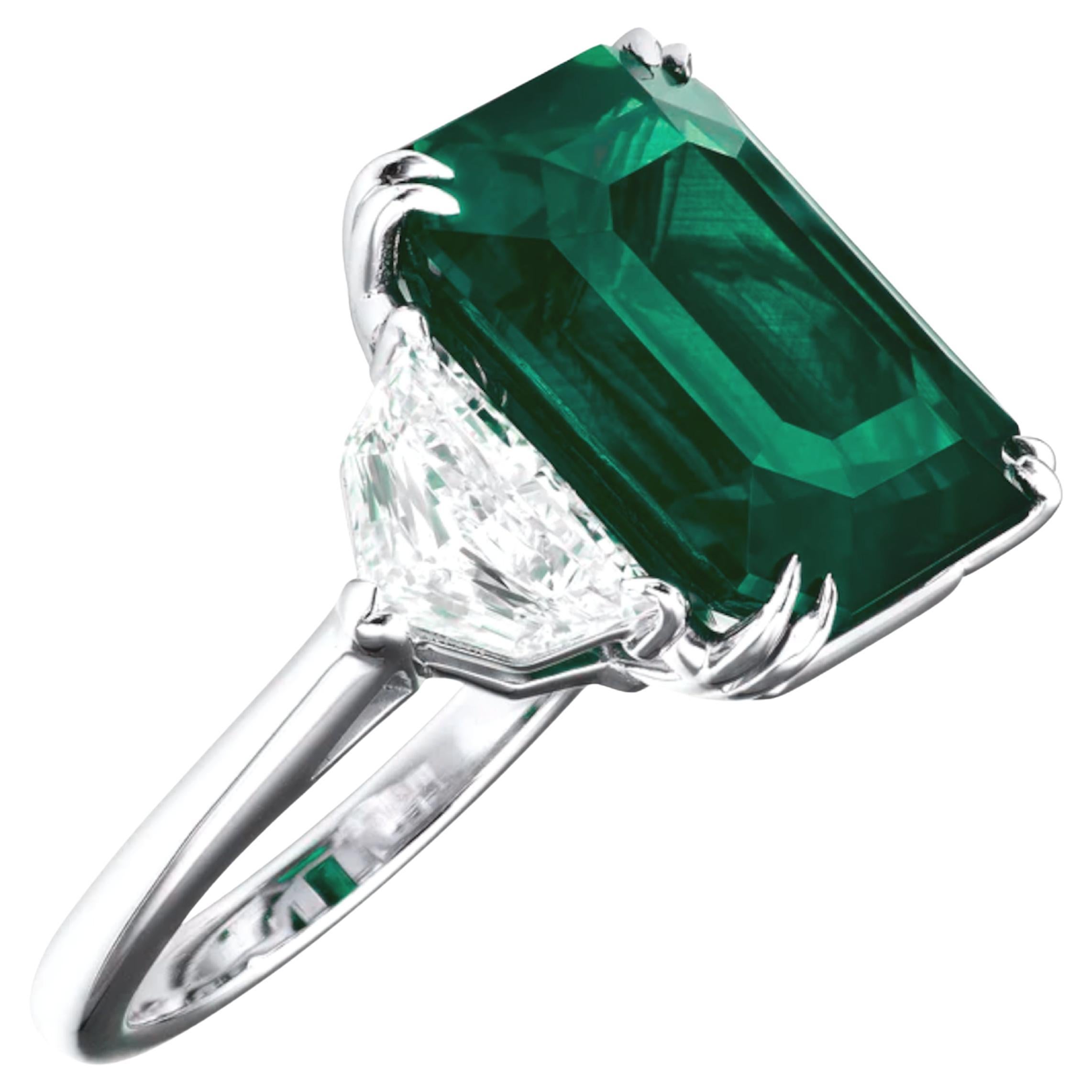  stunning emerald ring, featuring a magnificent 15.36 carat ICA Emerald, certified as a minor oil. This breathtaking centerpiece is beautifully complemented by two sparkling Cadillac diamonds, set in luxurious platinum. 

This unique piece of