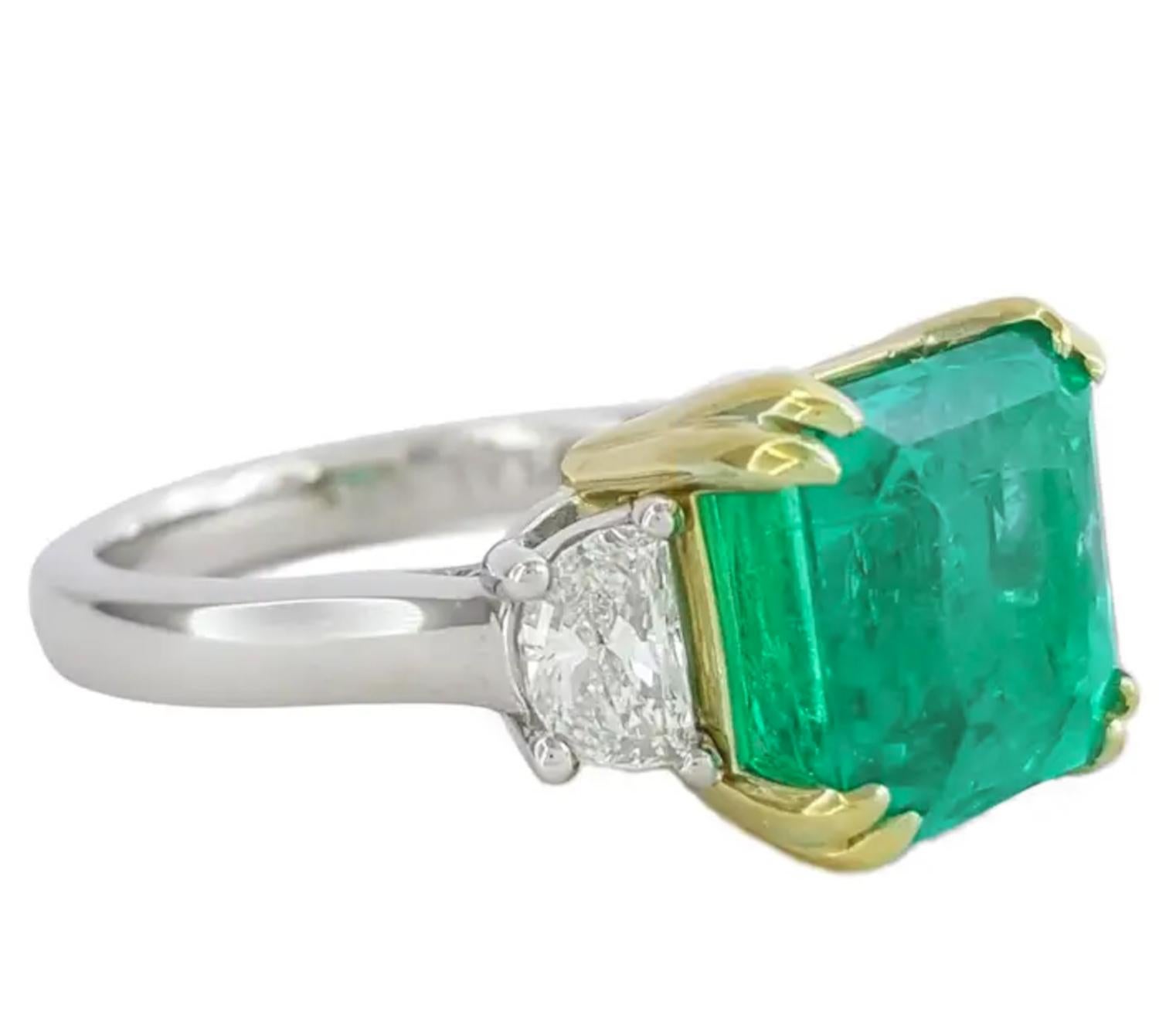 This striking ring showcases a vivid green 5.49-carat natural emerald, certified by GemLab, with origin traced to Zambia. The emerald features an octagonal step cut, highlighting its vibrant color and exceptional transparency. With only