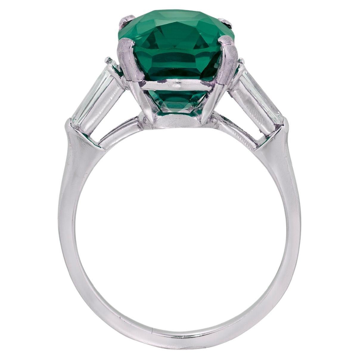 Experience the allure of luxury with this stunning 3.12-carat vivid green emerald, certified by the International Colored Gemstone Association, and expertly set in solid platinum. The vibrant emerald is complemented by two elegantly tapered