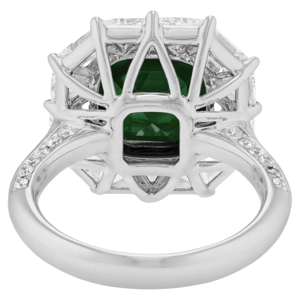emerald weighing 6.64 carats, with dimensions of 10.09 x 10.16 x 6.76 mm and a step-cut shape. The emerald displays a vivid green color and is transparent, adding a stunning allure to the piece. 

This elegant emerald is beautifully complemented by