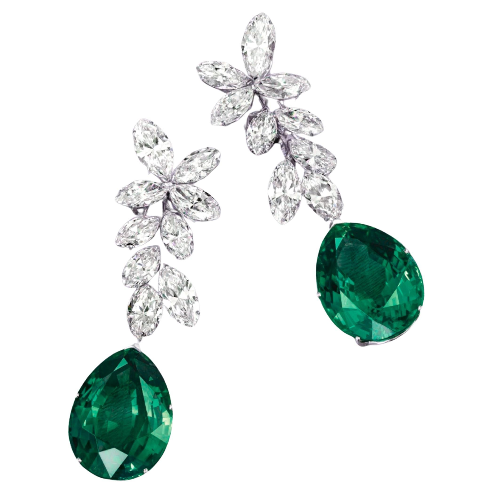  ICA LAB Certified 7.50 Carat Pear Cut Green Emerald Dangle Diamond Earrings feature a vibrant 7.50-carat pear-cut green emerald, certified by ICA LAB to affirm its authenticity and quality. These stunning earrings are further adorned with 3 carats