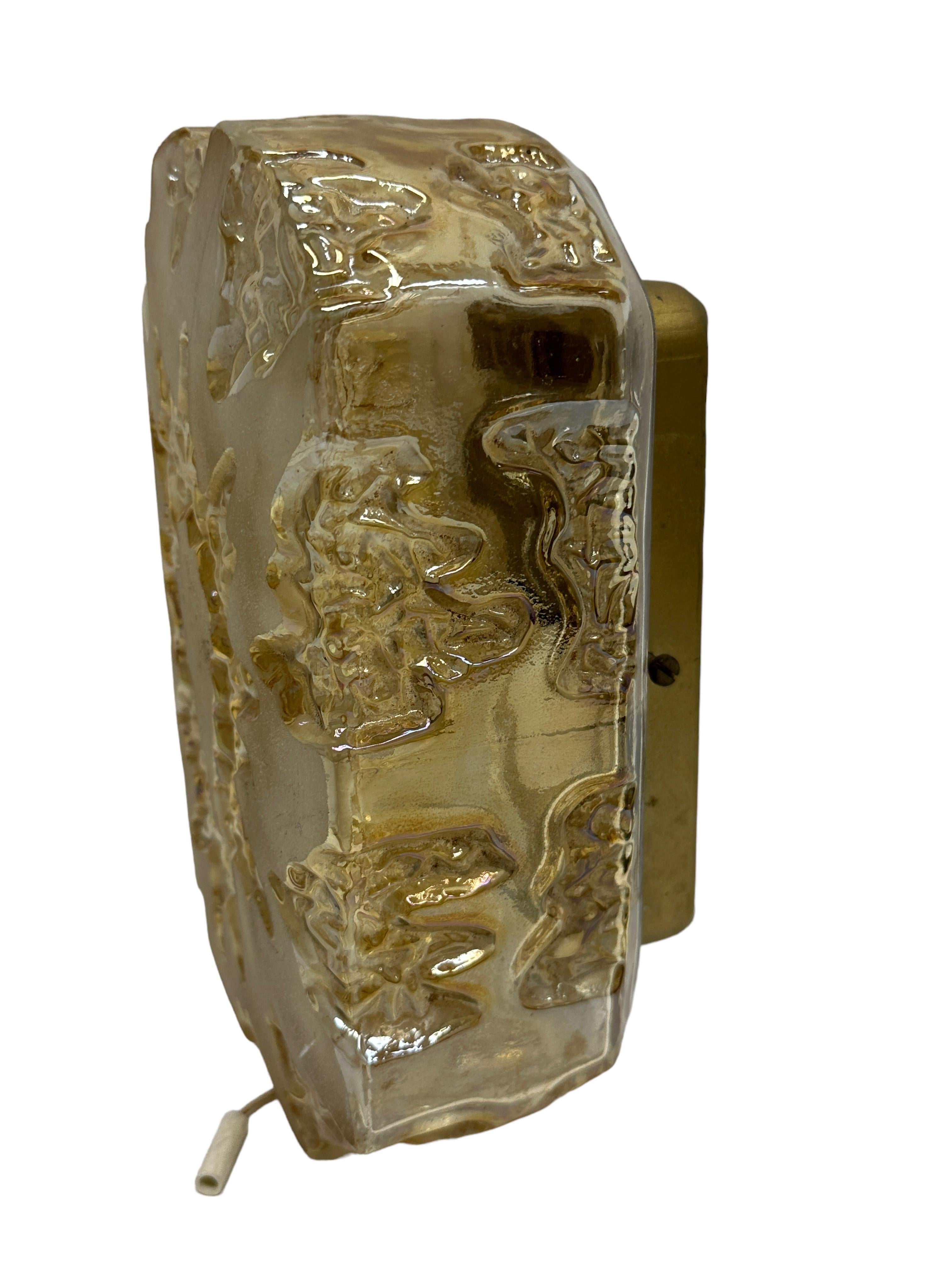 Petite sconce manufactured by Honsel Leuchten Germany. It is a amber tone glass on a gilded metal frame. The fixture has one European style E14 socket. It requires a European E14 candelabra bulb, up to 40 Watt. A nice Wall Lamp for your entry hall