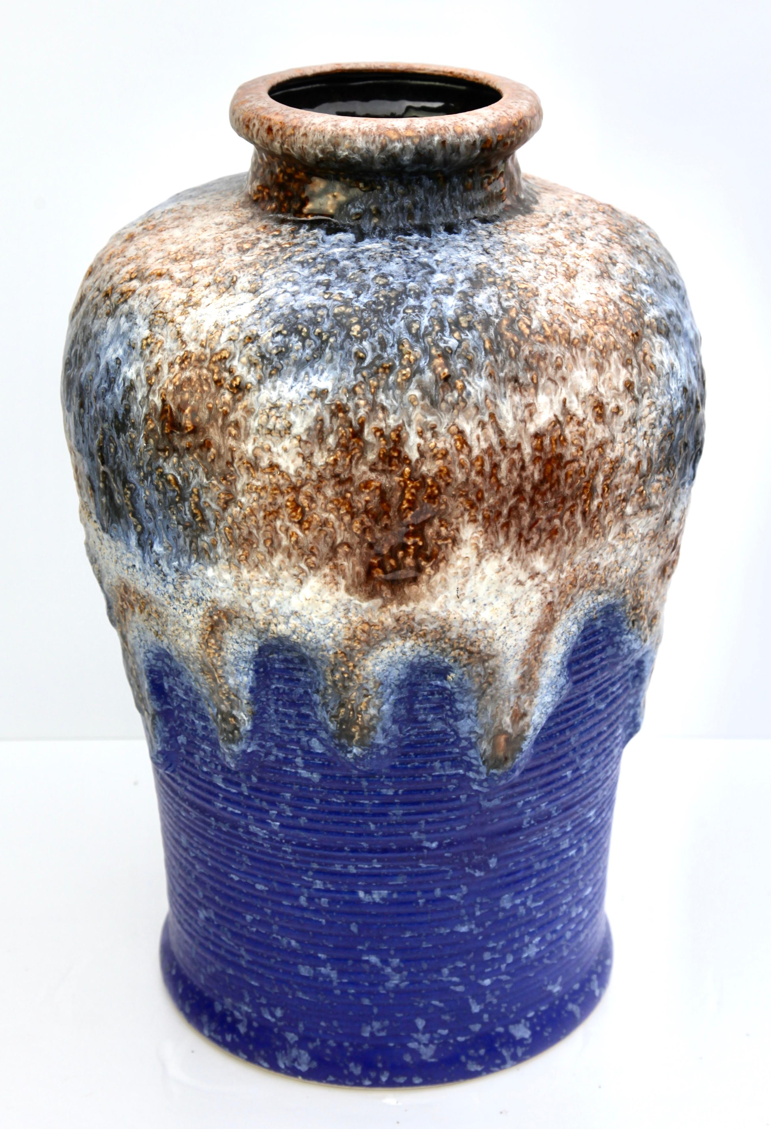 Fat lava floor vase with a rarely-seen form and decor. Heavy ridged body being deluged under a very thick layer of white and brown lava including iridescent/cristalline grains.
An unusual combination of colors and surfaces made by Dumler & Breiden