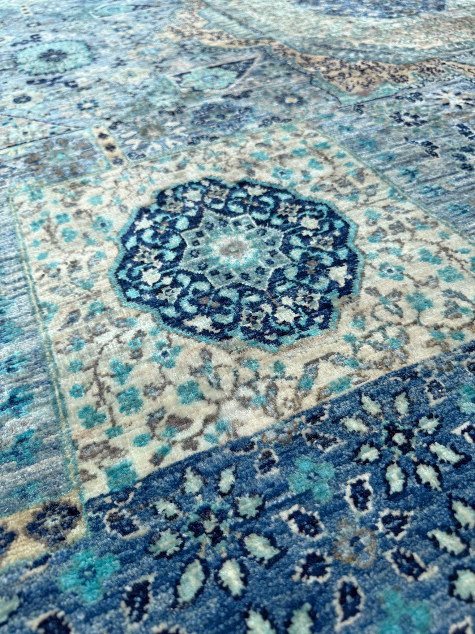 This Ice Blue Fine Mamluk Transitional Rug celebrates the serenity of cool tones—from icy aquas to deep sapphires—woven together like ripples across a calm sea. A complex central medallion anchors the design, surrounded by a mesmerizing interplay of