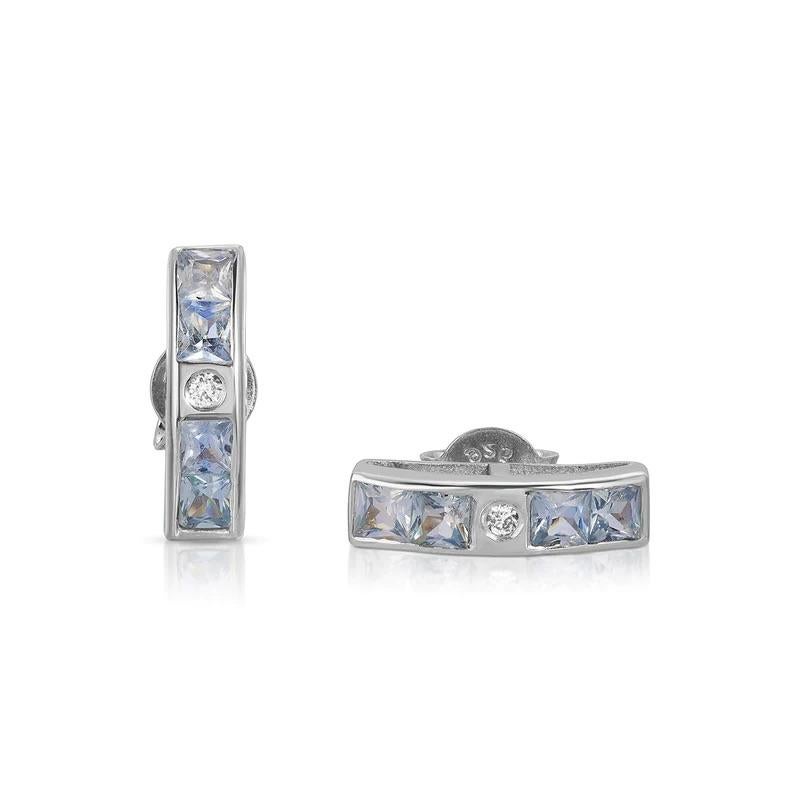 Les boucles d'oreilles Baguette en saphir bleu glacier avec diamants présentent des rangées de baguettes de saphir bleu glacier avec des diamants centraux dans de parfaits petits clous d'oreilles en forme de bâtonnets.

- Le saphir pèse environ 1,22