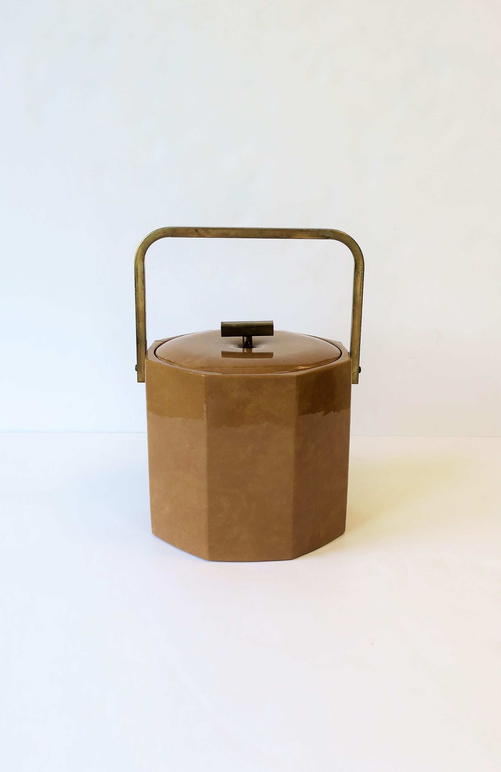 A chic goatskin style ice bucket or wine/champagne cooler by designer Georges Briard, circa 1970s. Ice bucket has and octagonal exterior shape and brass-tone metal handles.

Measurements: 
13