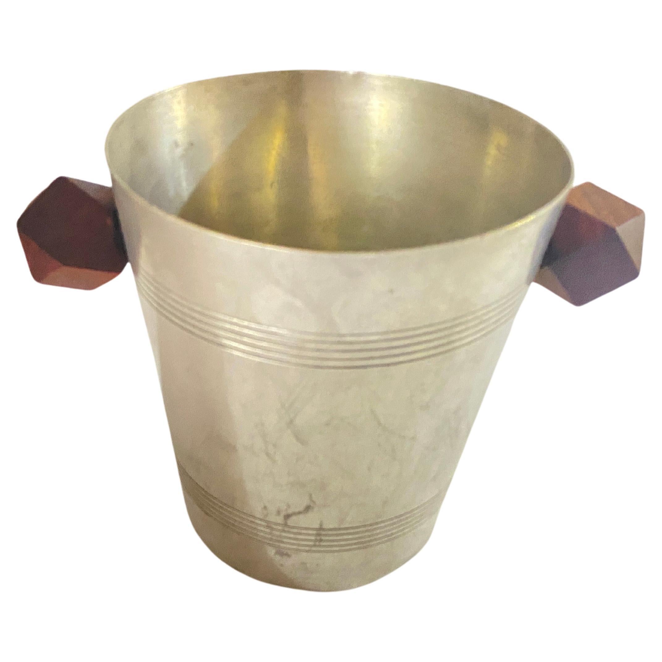 This ice bucket is in gold and silver metal, with wood Handles. It comes from France, and has been made circa 1930.
Beautiful old patina, and Art Deco style.